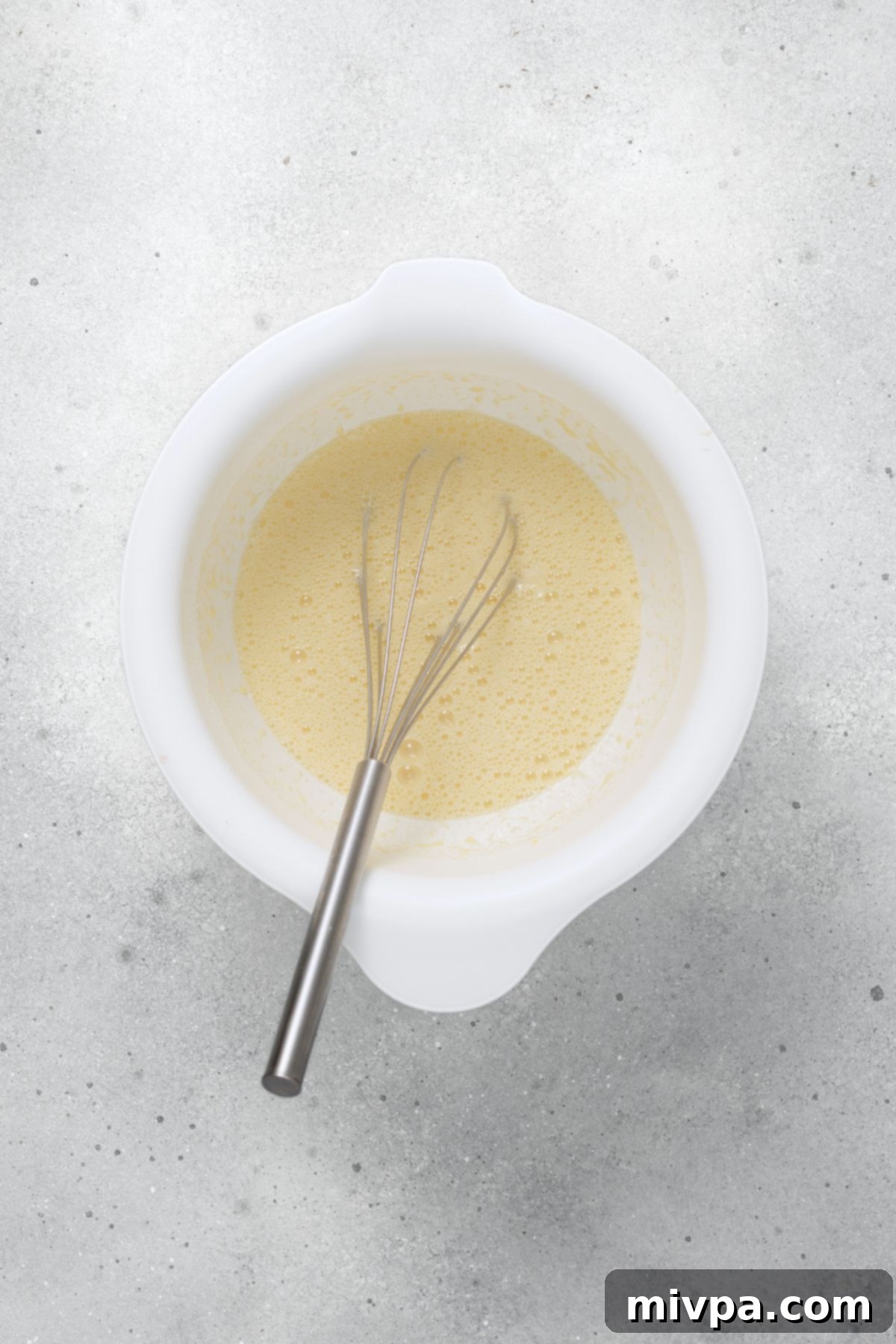 Gluten-Free Dairy-Free Dutch Baby Whisk in a bowl of pancake batter.