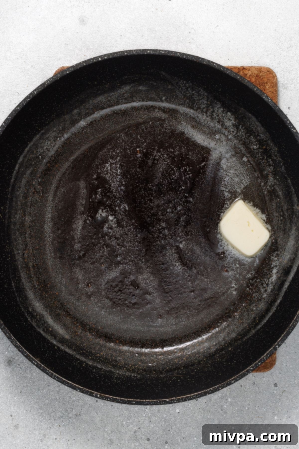 Gluten-Free Dutch pancake Melting butter in a cast iron skillet