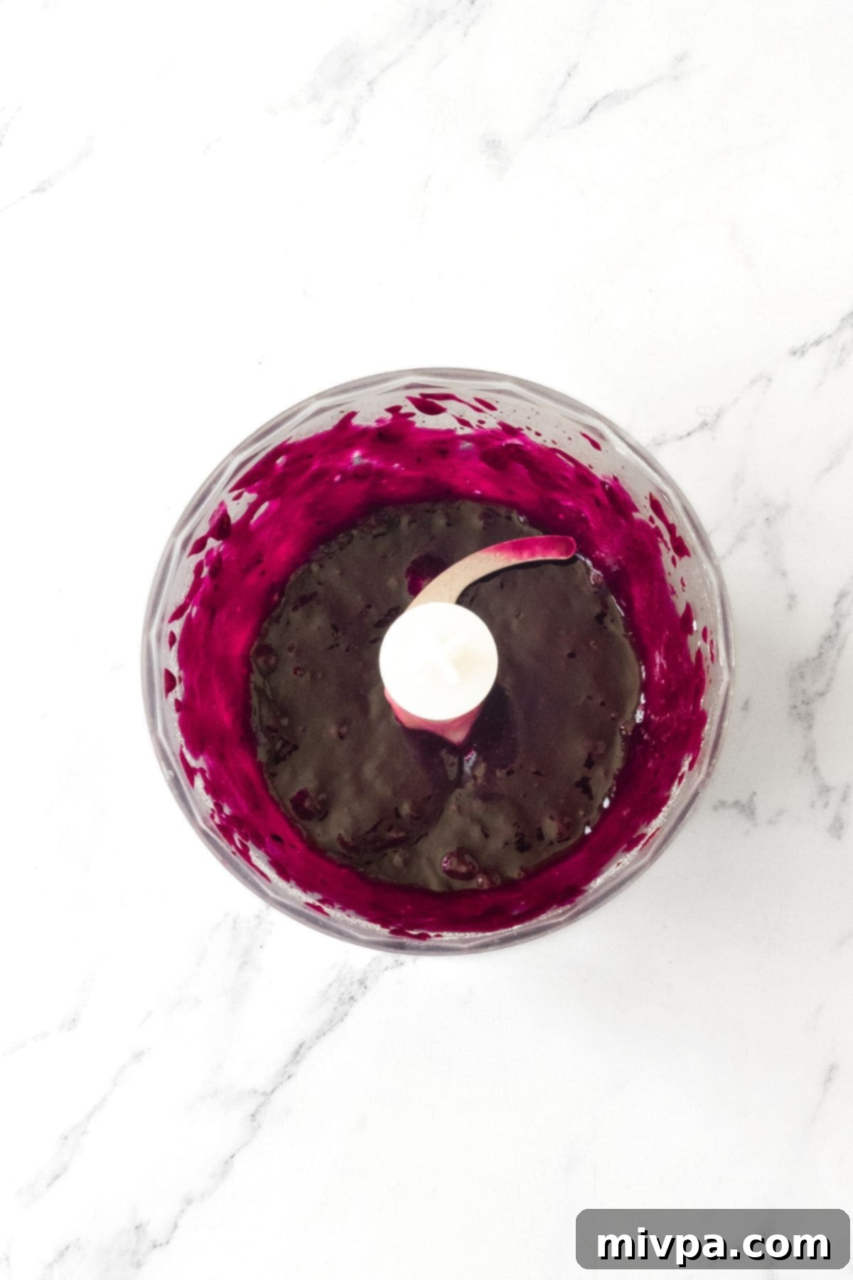 Blueberry Glaze Recipe for Donuts Step 2 A smooth, vibrant blueberry puree resting in a food processor, after being blended to perfection.