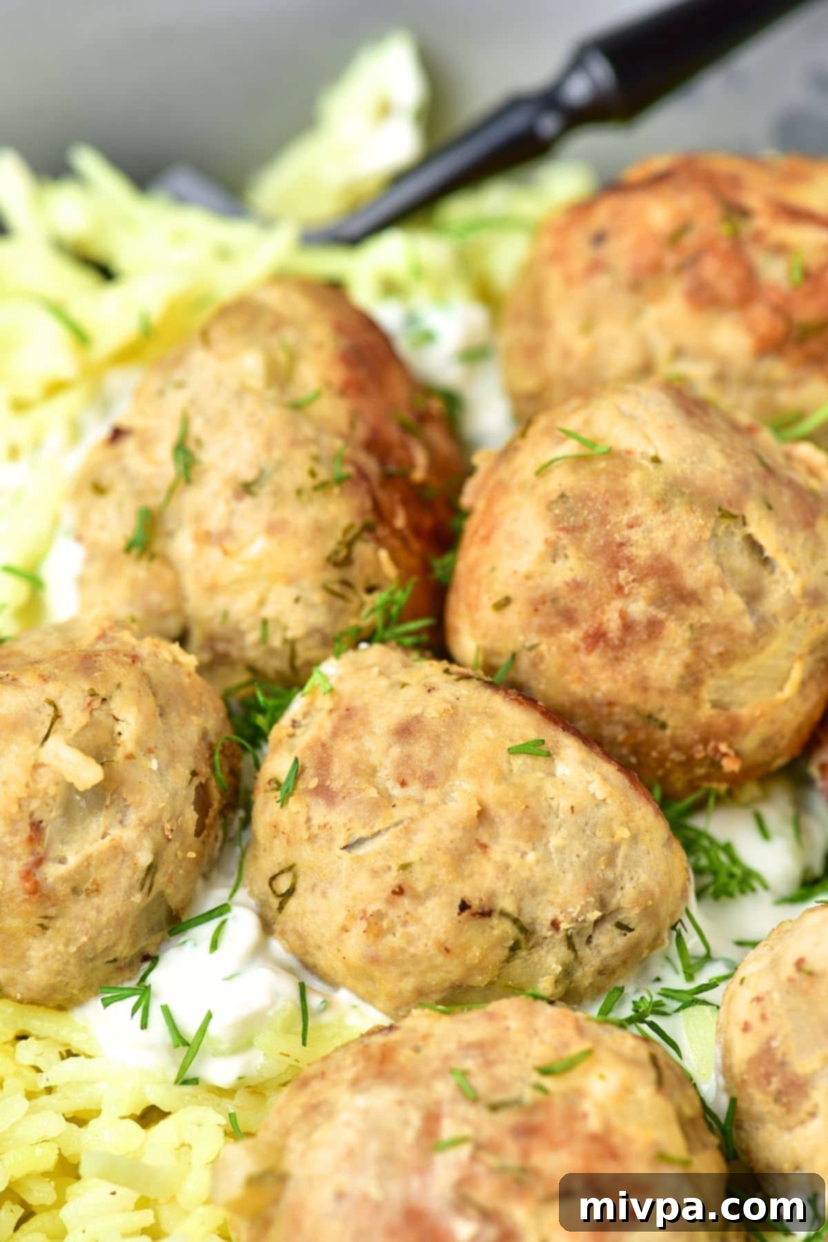 An up-close shot of ground turkey feta meatballs, beautifully garnished with fresh dill sprigs.
