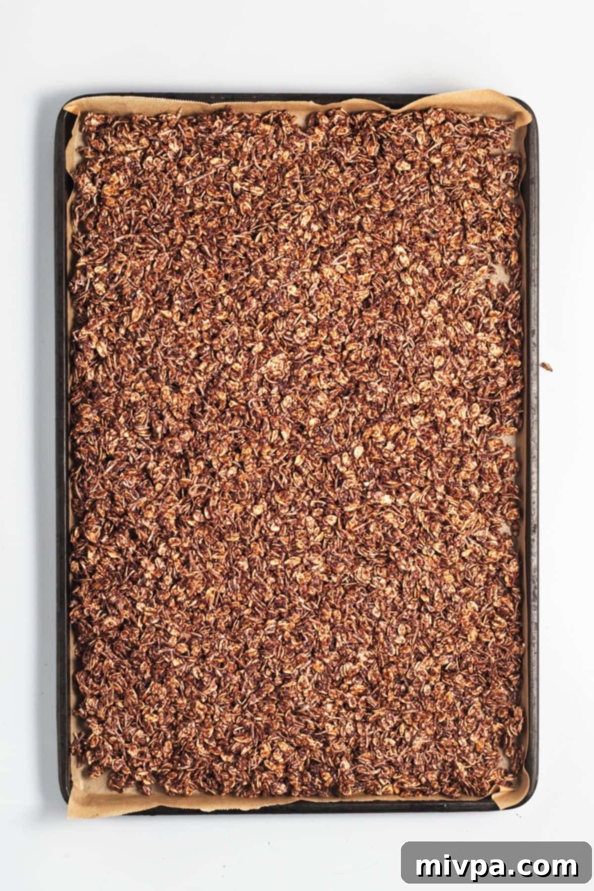 Homemade Chocolate Granola (Gluten-Free, Vegan) Homemade chocolate granola spread out on baking sheet