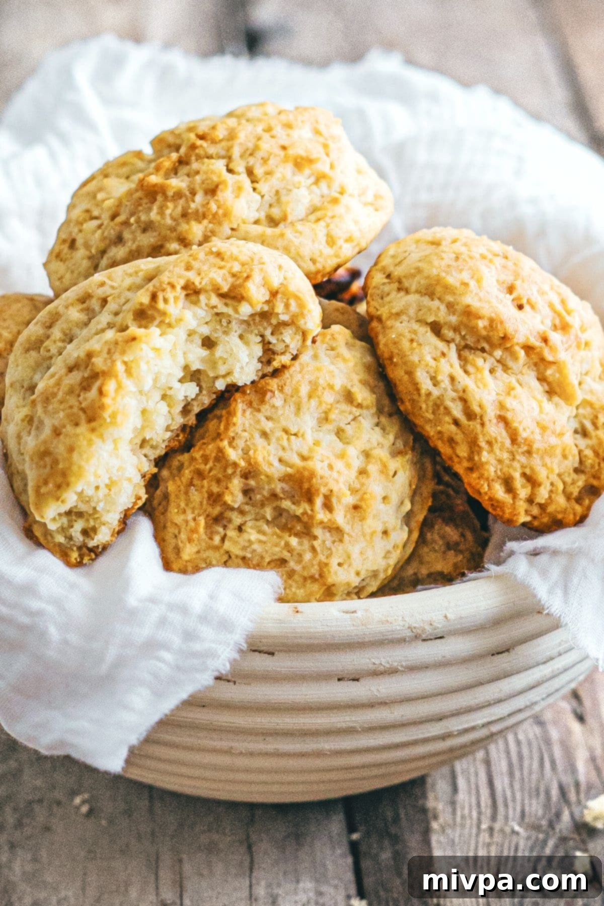 A charming basket overflowing with freshly baked gluten-free drop biscuits, golden brown and inviting.