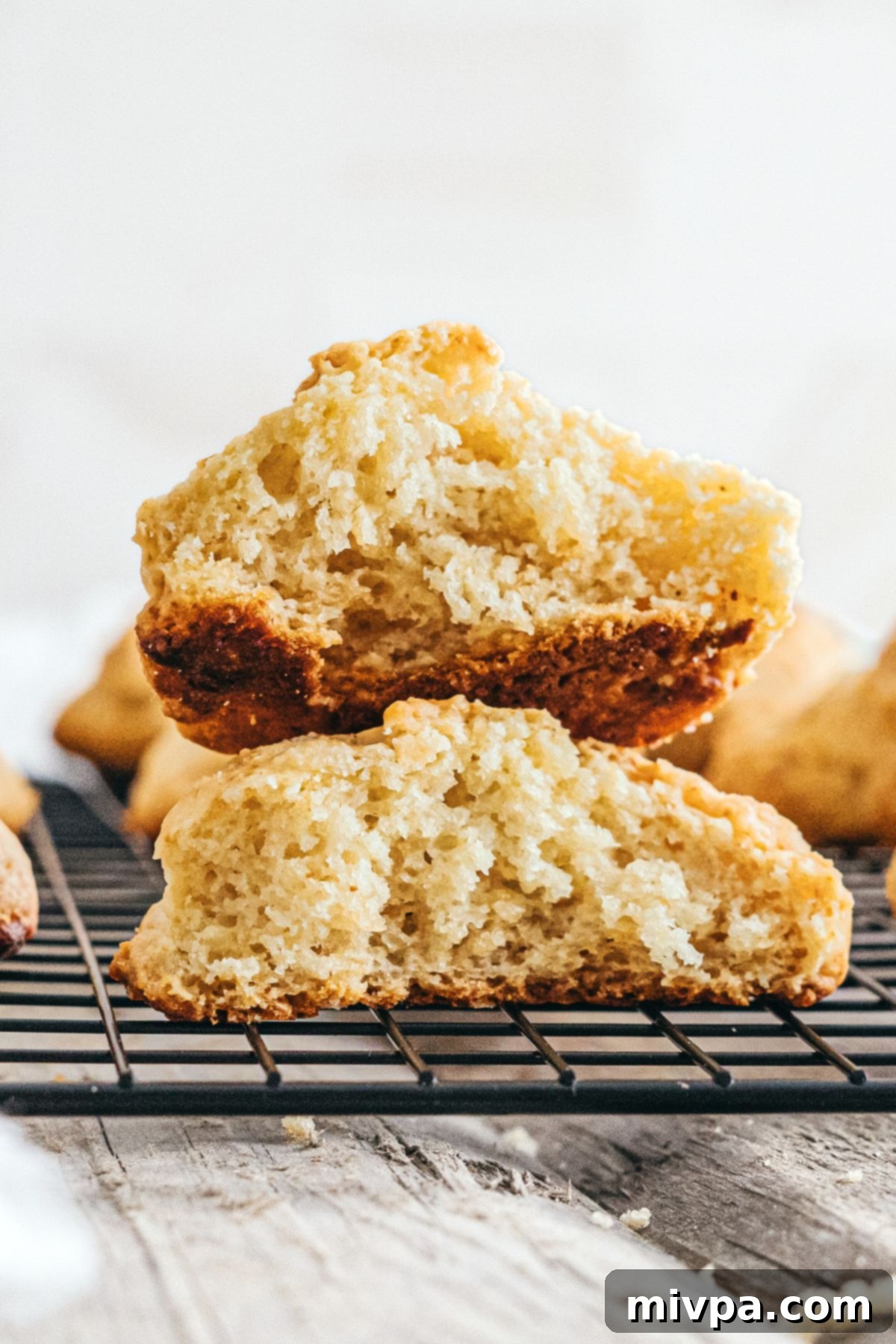 A stack of two half-eaten gluten-free dairy-free drop biscuits, showing their tender, flaky interior and golden crust.