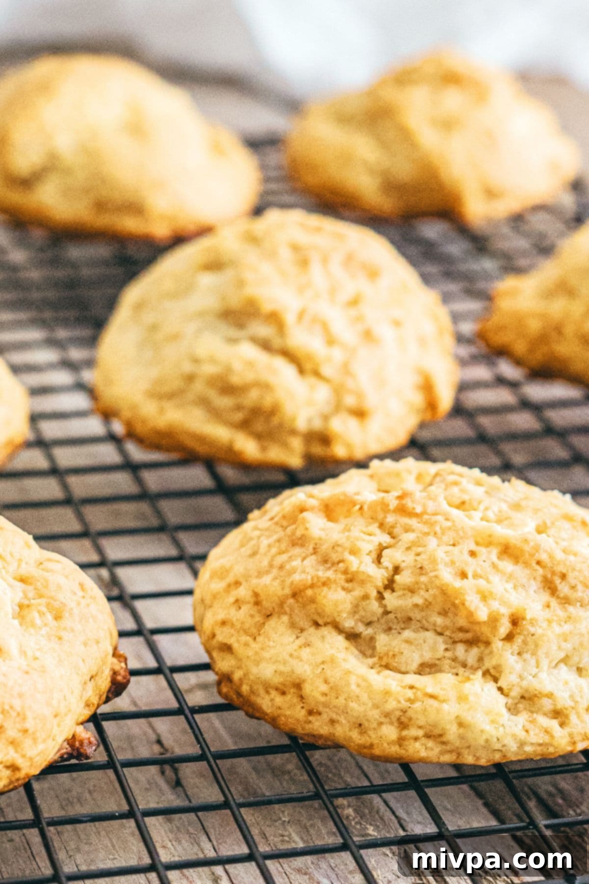 Freshly baked gluten-free vegan drop biscuits cooling on a wire rack, with a golden-brown crust.