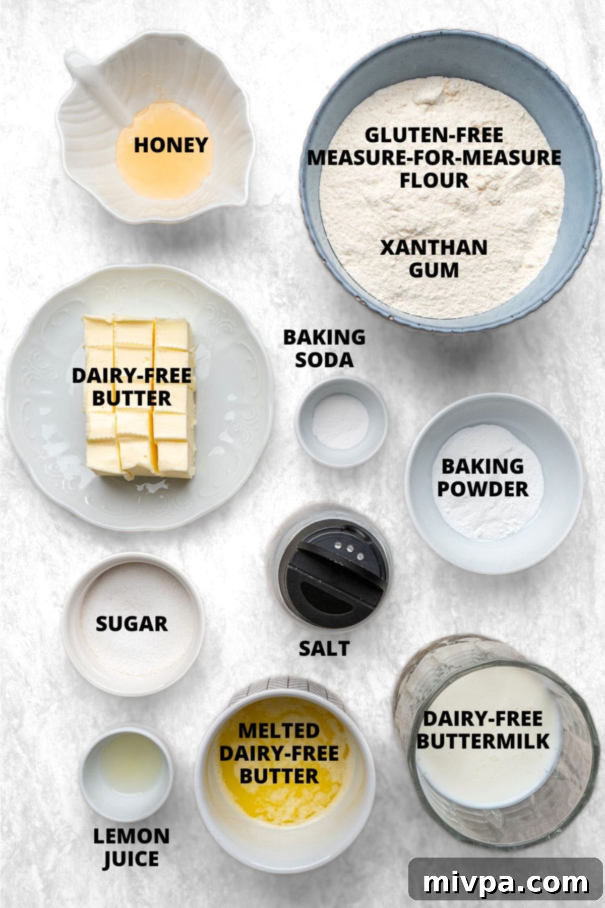 All ingredients for gluten-free dairy-free drop biscuits recipe meticulously laid out on a clean white board.