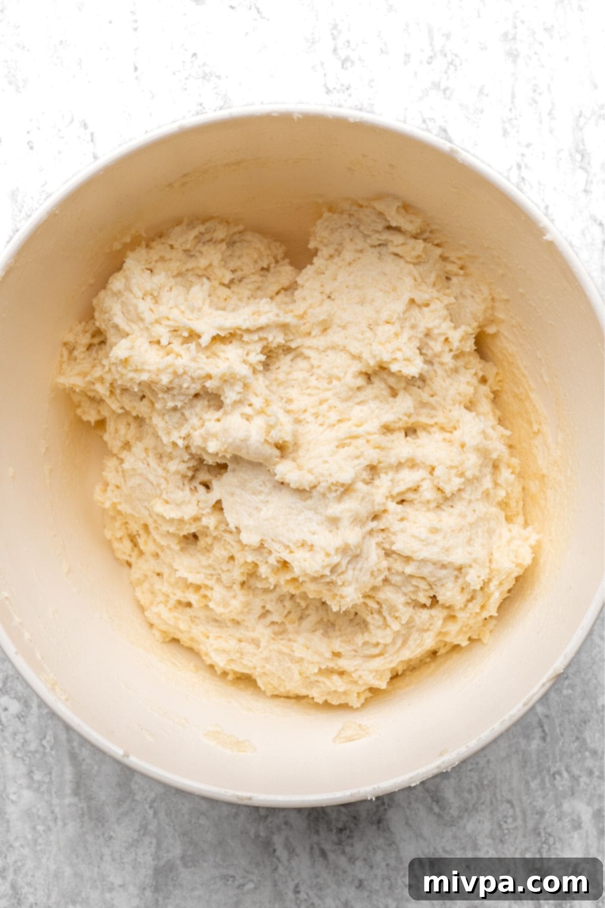 Shaggy and slightly sticky biscuit dough in a mixing bowl, just combined.