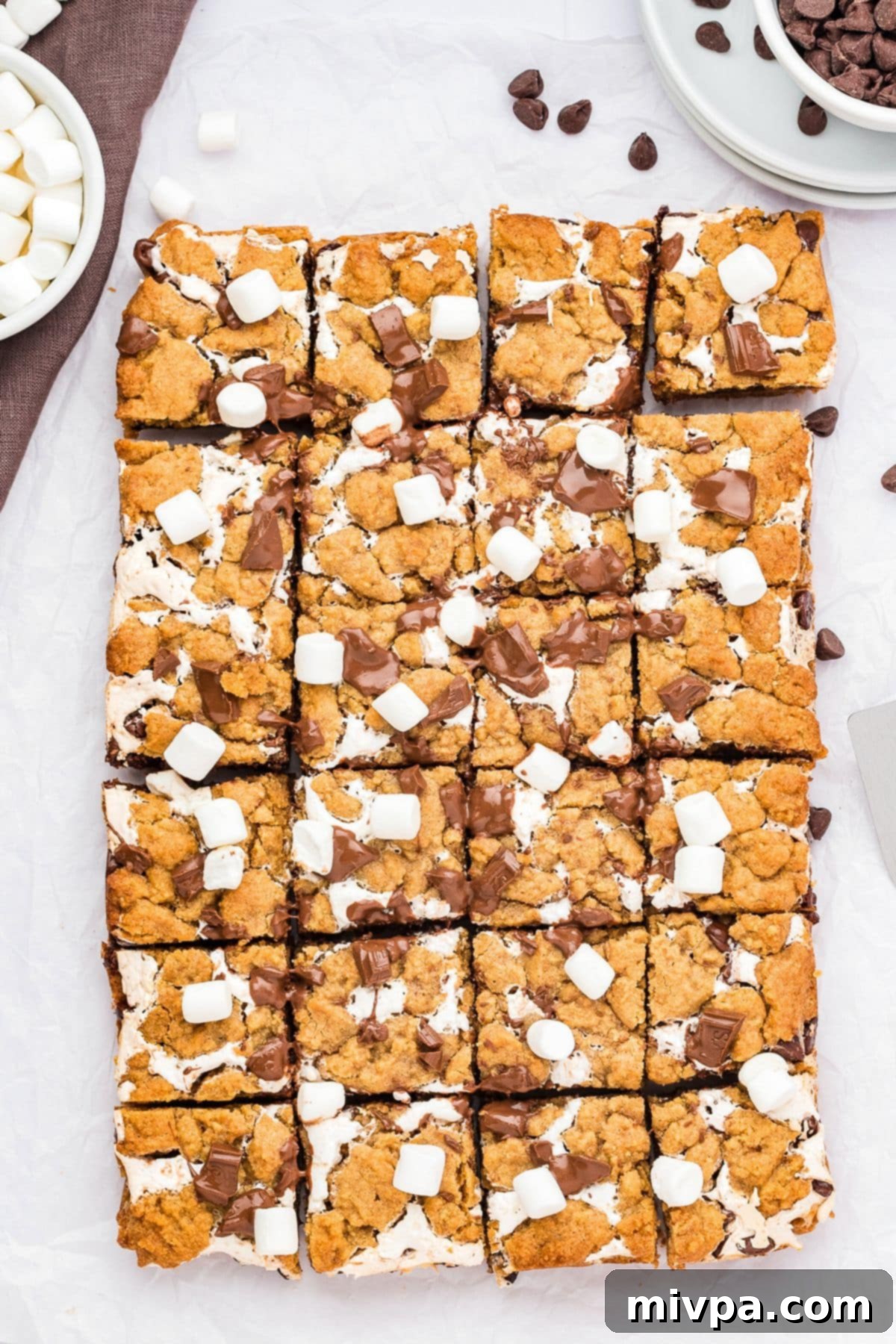 Fully cooled and neatly sliced gluten-free s'mores dessert bars resting on parchment paper, showcasing their perfect layers, ready to be enjoyed.
