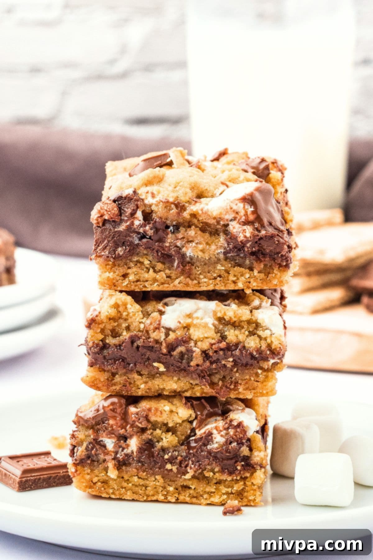 A tempting stack of perfectly baked gluten-free s'mores bars, ready to be served and enjoyed, showing their distinct layers of crust, chocolate, and marshmallow.