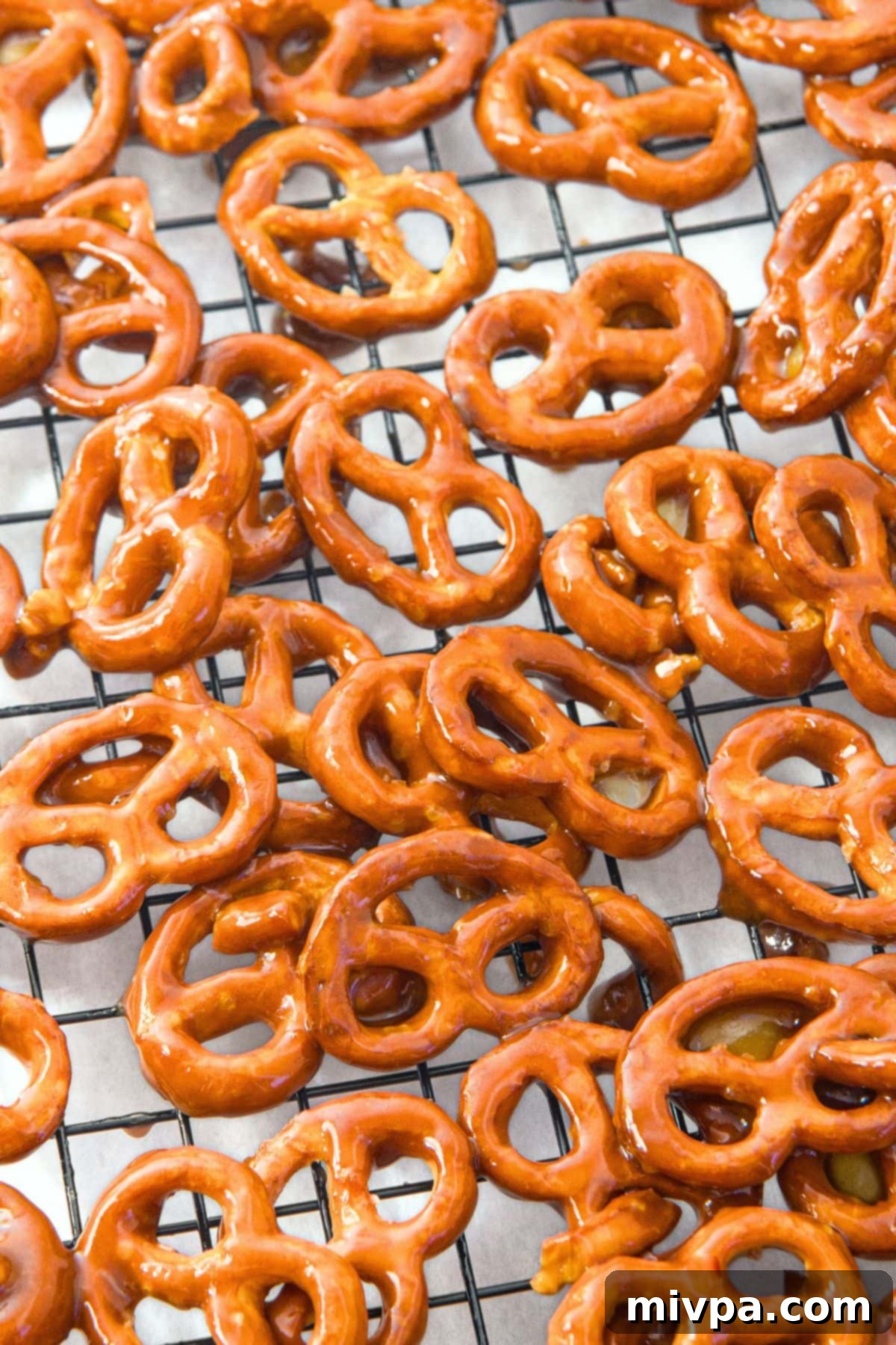 Cooling Easy Butter Toffee Pretzels (Gluten-Free, Dairy-Free) Coated toffee pretzels spread out in a single layer on a wire rack for cooling and setting.