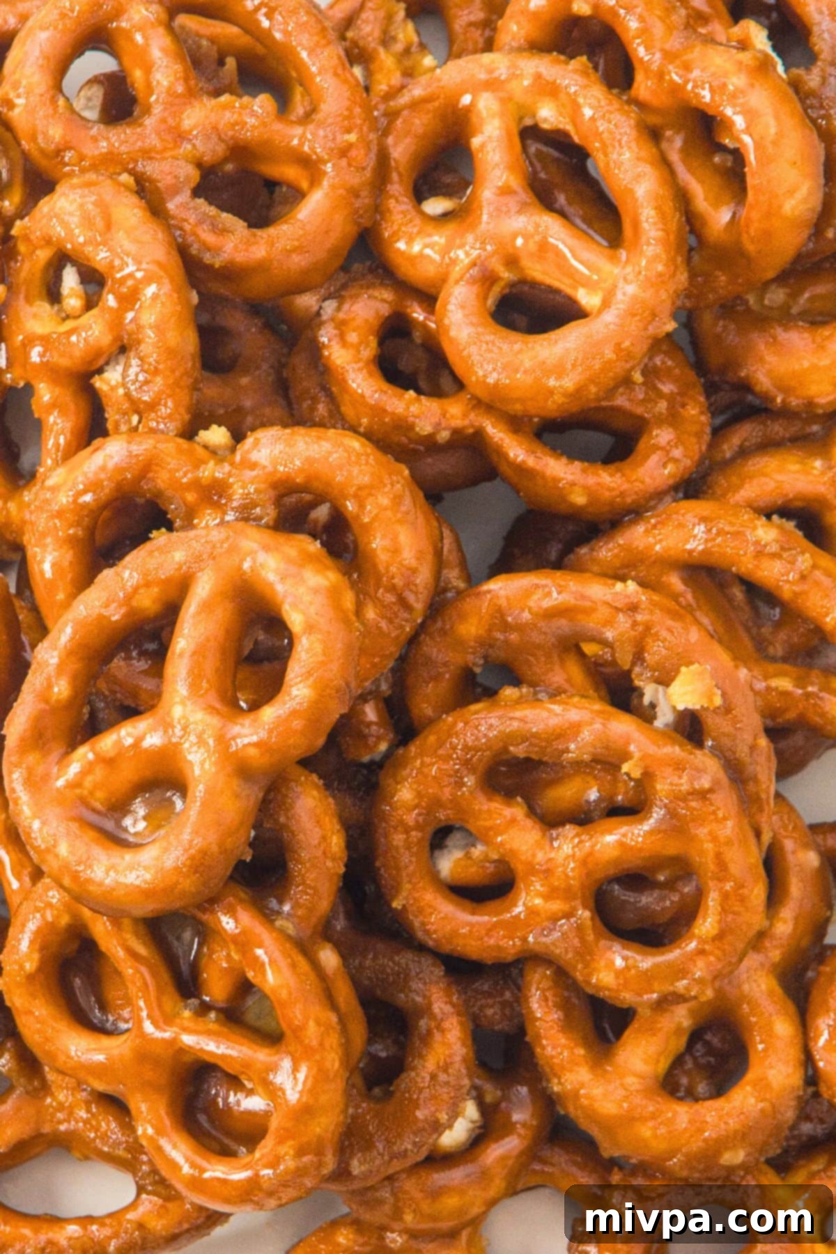 Homemade Toffee Pretzels (Gluten-Free, Dairy-Free Option) Up close view of golden brown butter toffee pretzels on a white plate, highlighting their crunchy texture.