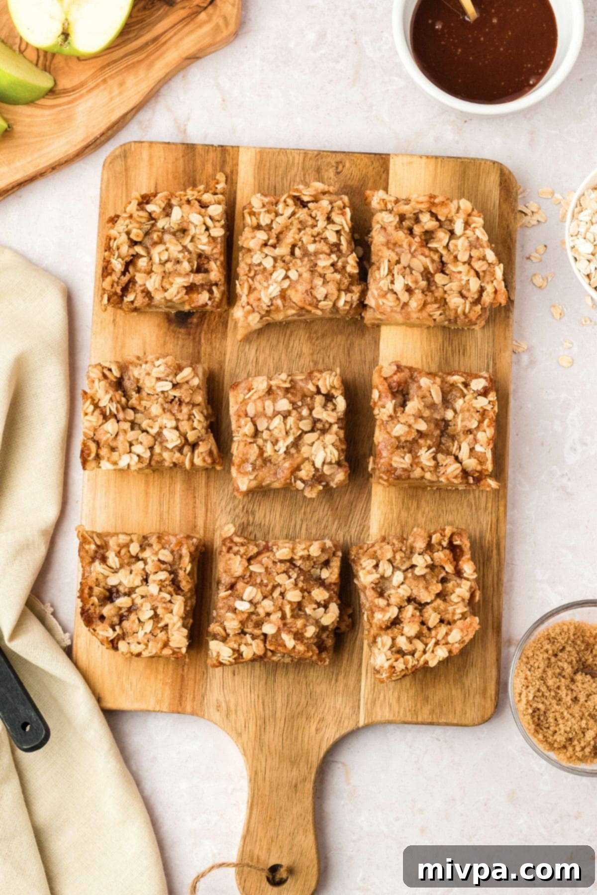 Gluten-Free Apple Pie Bars (Vegan) Gluten-free apple pie bars on wooden board, showcasing a perfect slice.