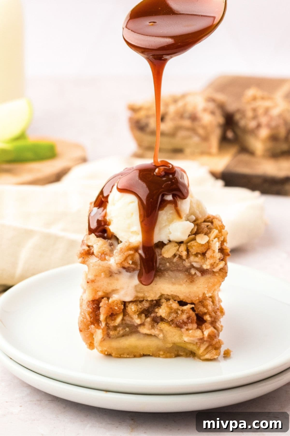 Gluten-Free Dairy-Free Apple Pie Bars Drizzling caramel sauce over a stack of warm apple bars.