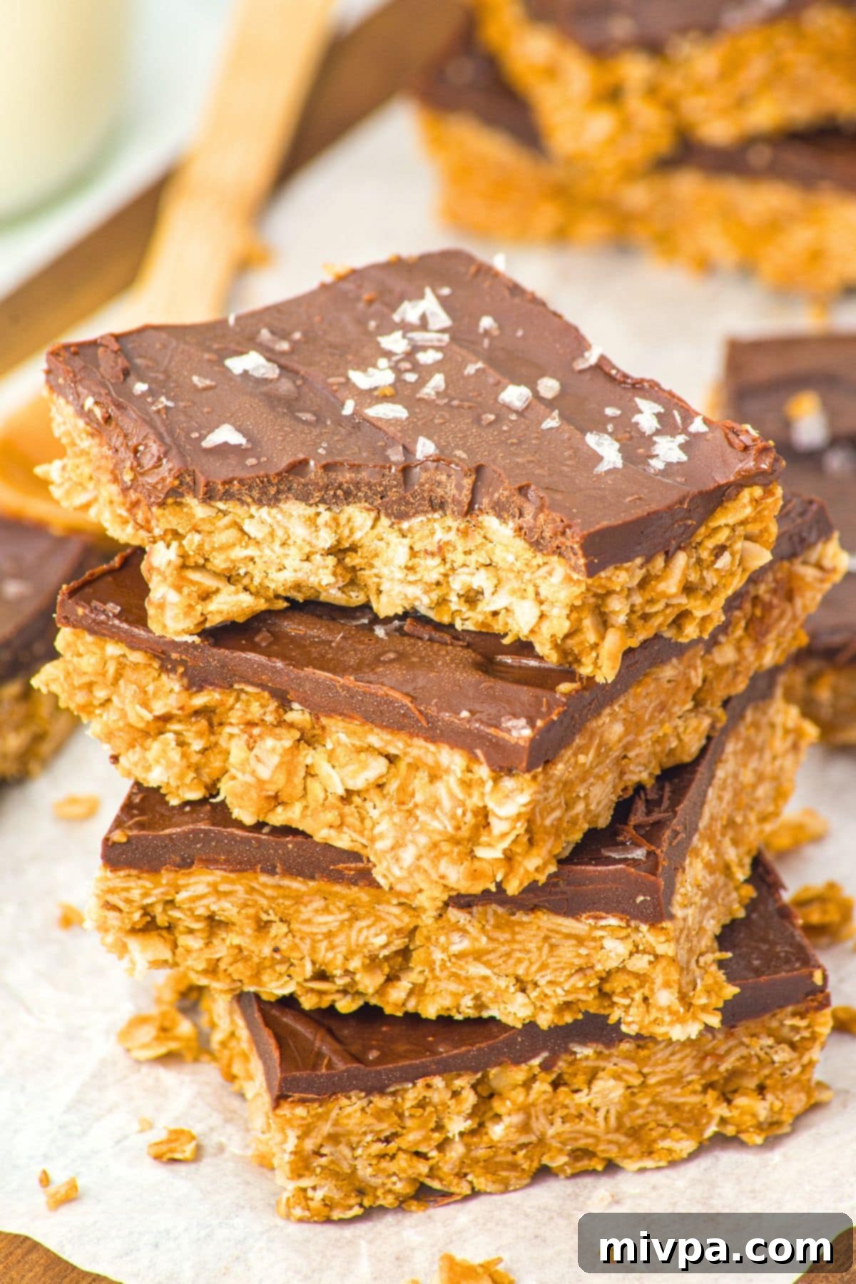 Peanut Butter Chocolate Oatmeal Bars (Gluten-Free, Vegan) A stack of half-eaten no-bake peanut butter chocolate oatmeal bars, showcasing their distinct layers.