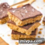 Wholesome Vegan Gluten-Free Peanut Butter Chocolate Oat Bars 2 A stack of peanut butter chocolate oatmeal bars with visible layers.