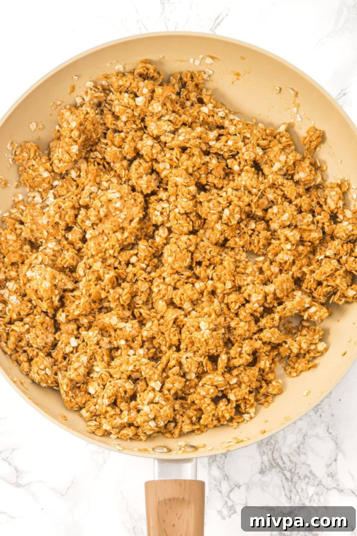 Peanut Butter and Chocolate Oatmeal Bars Oats and salt being added to the warm peanut butter mixture in a skillet.