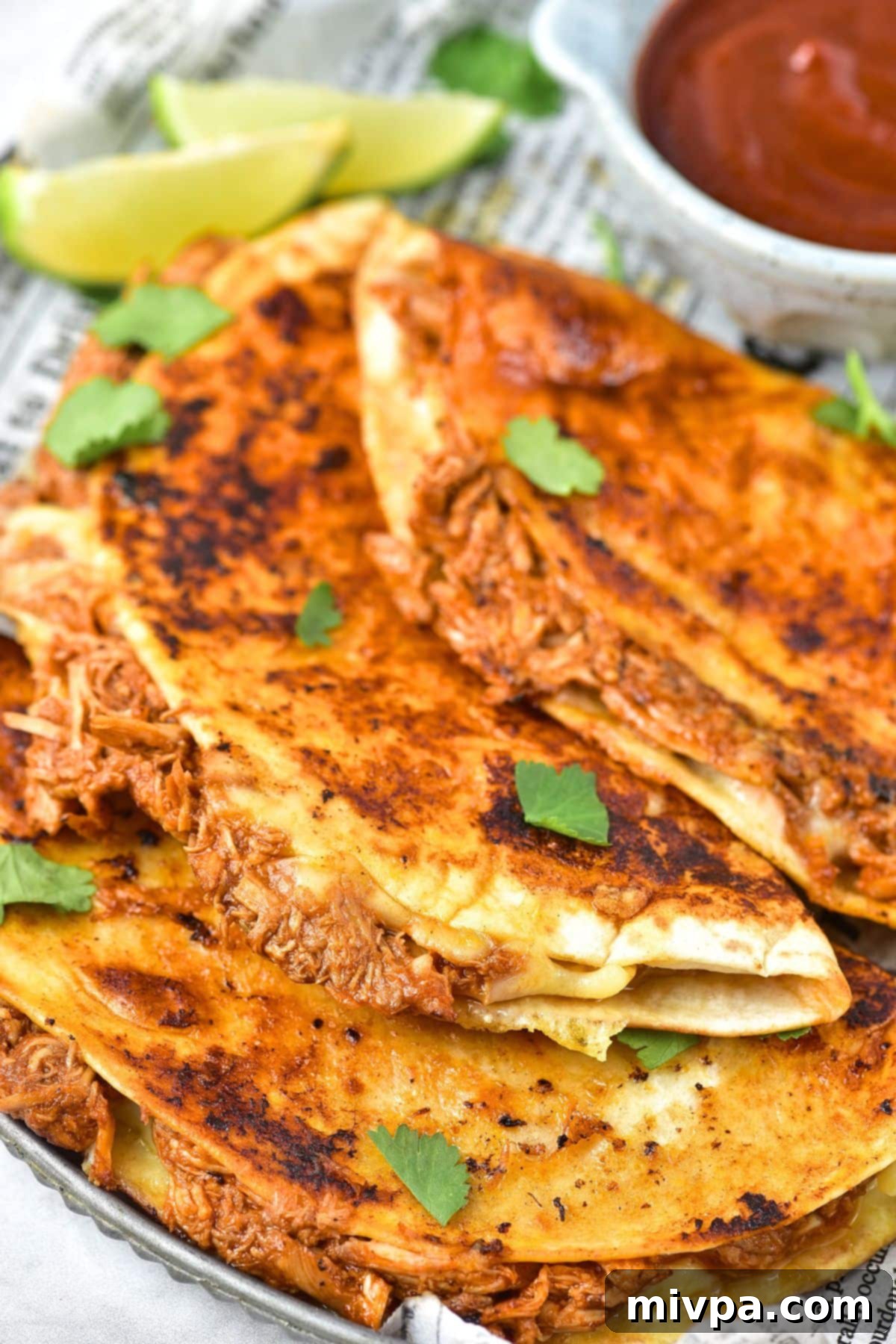 Birria Chicken Tacos (Gluten-Free, Dairy-Free Option) Up close view of birria chicken tacos on a plate, showing the crispy tortilla and melted cheese.