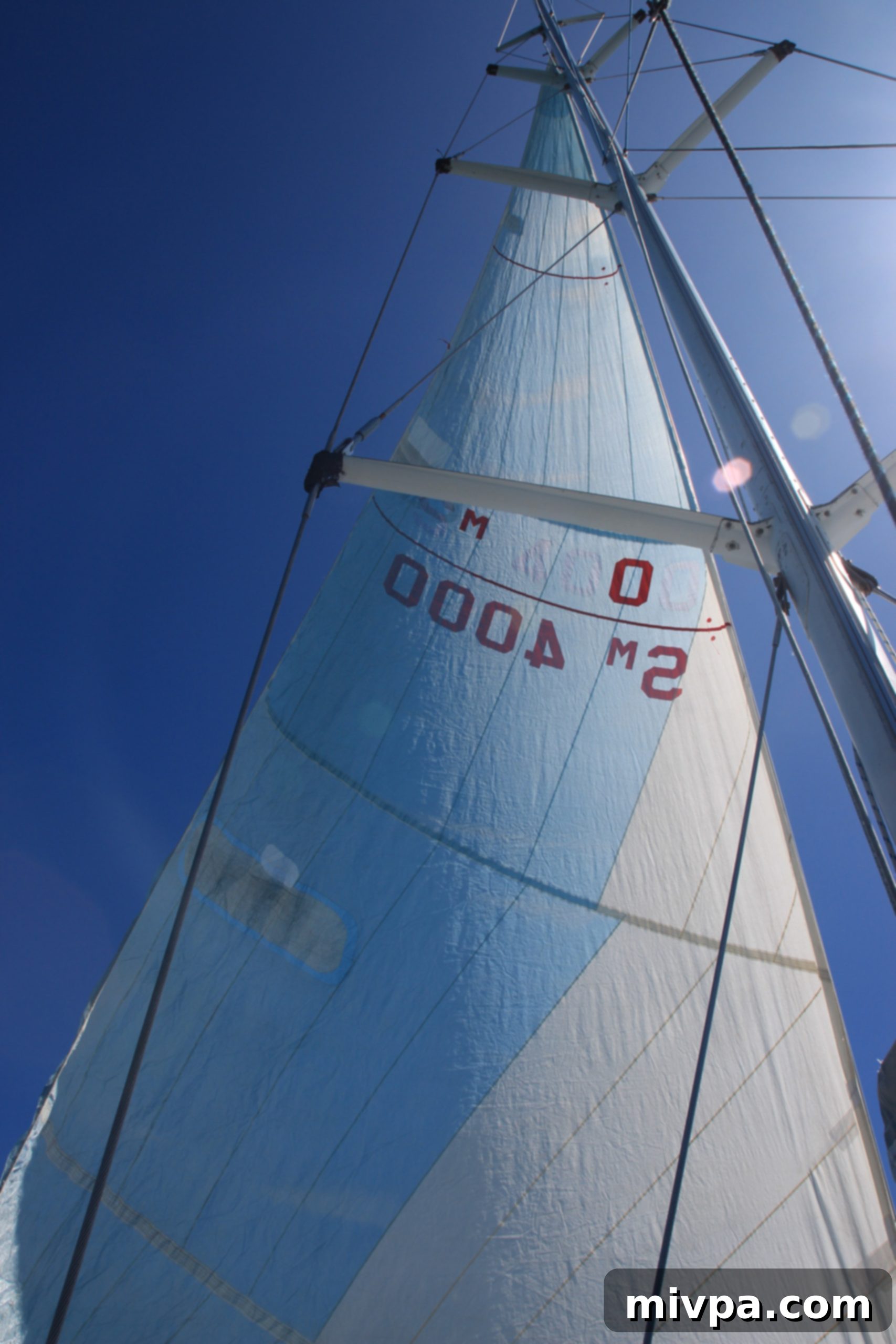 Couple posing happily next to the majestic sails on a sailboat in the Whitsundays
