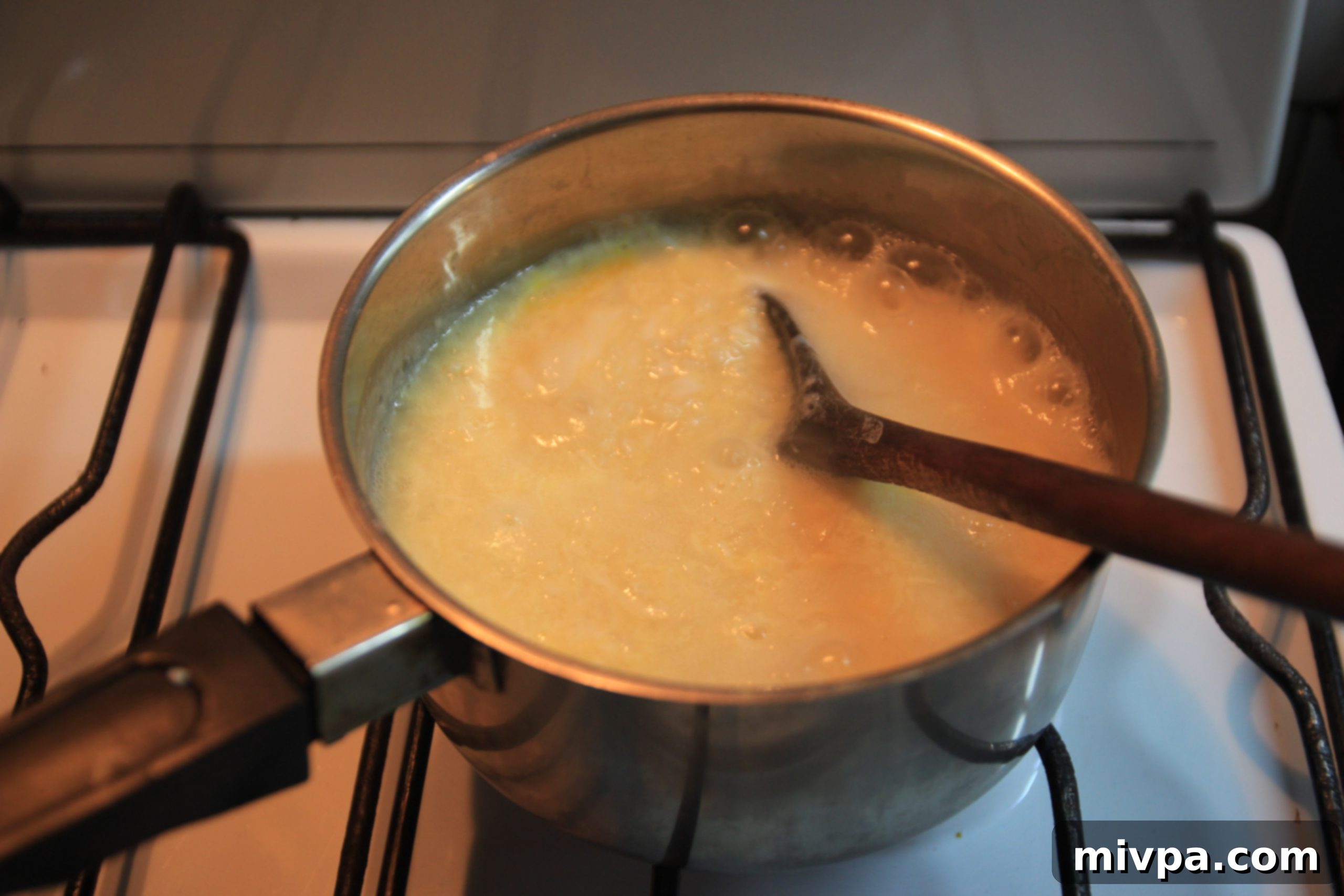 Beaten eggs being stirred into simmering rice porridge, creating a marbled effect, with seasoning added.