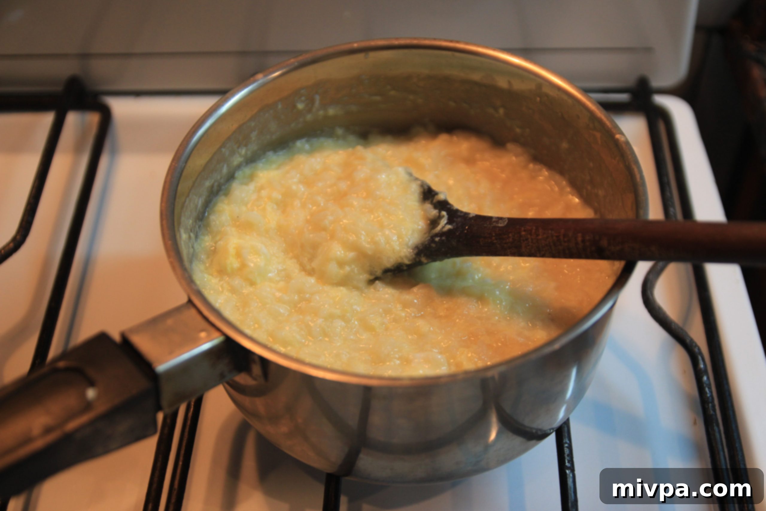 A spoon stirring the creamy egg porridge to achieve the perfect desired consistency.