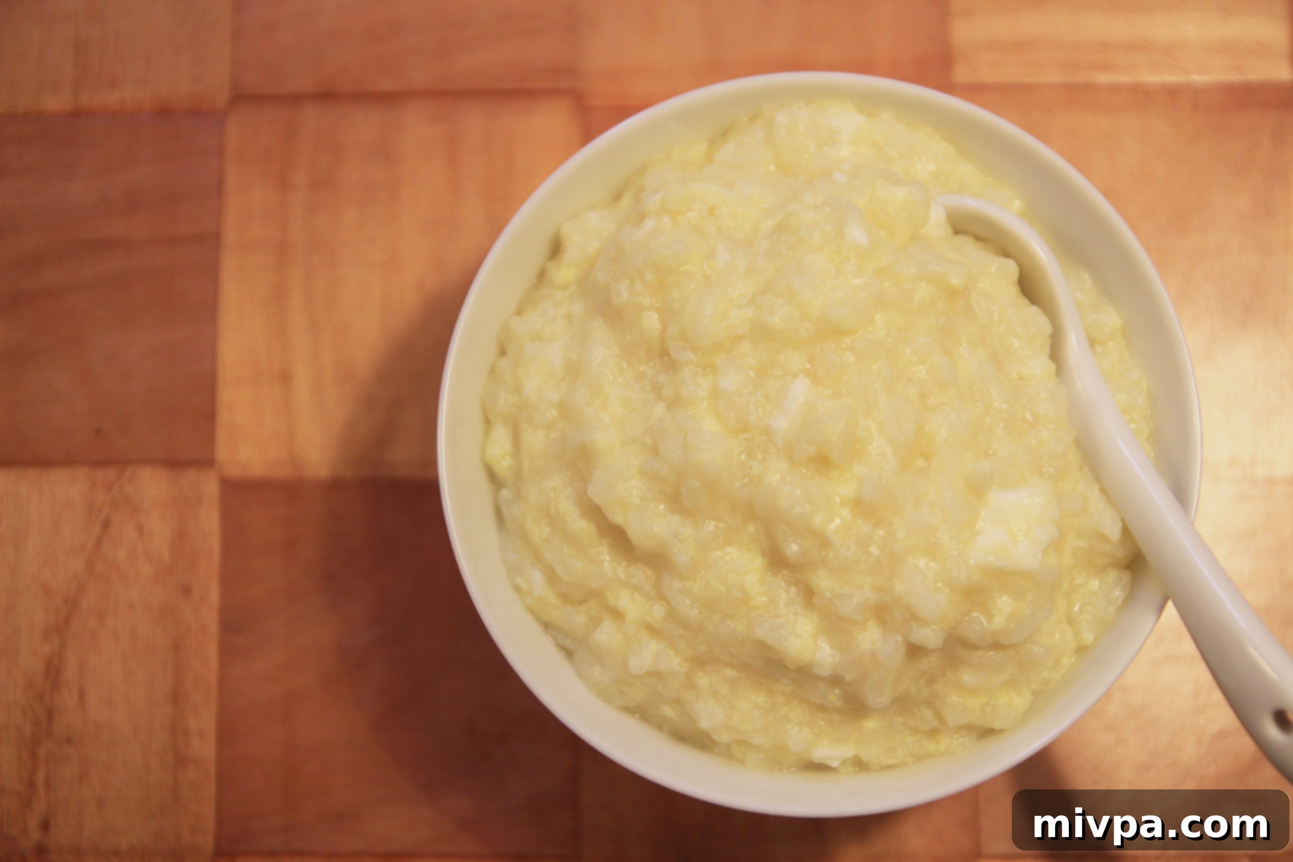 Another view of the egg porridge, showcasing its texture and garnishes.
