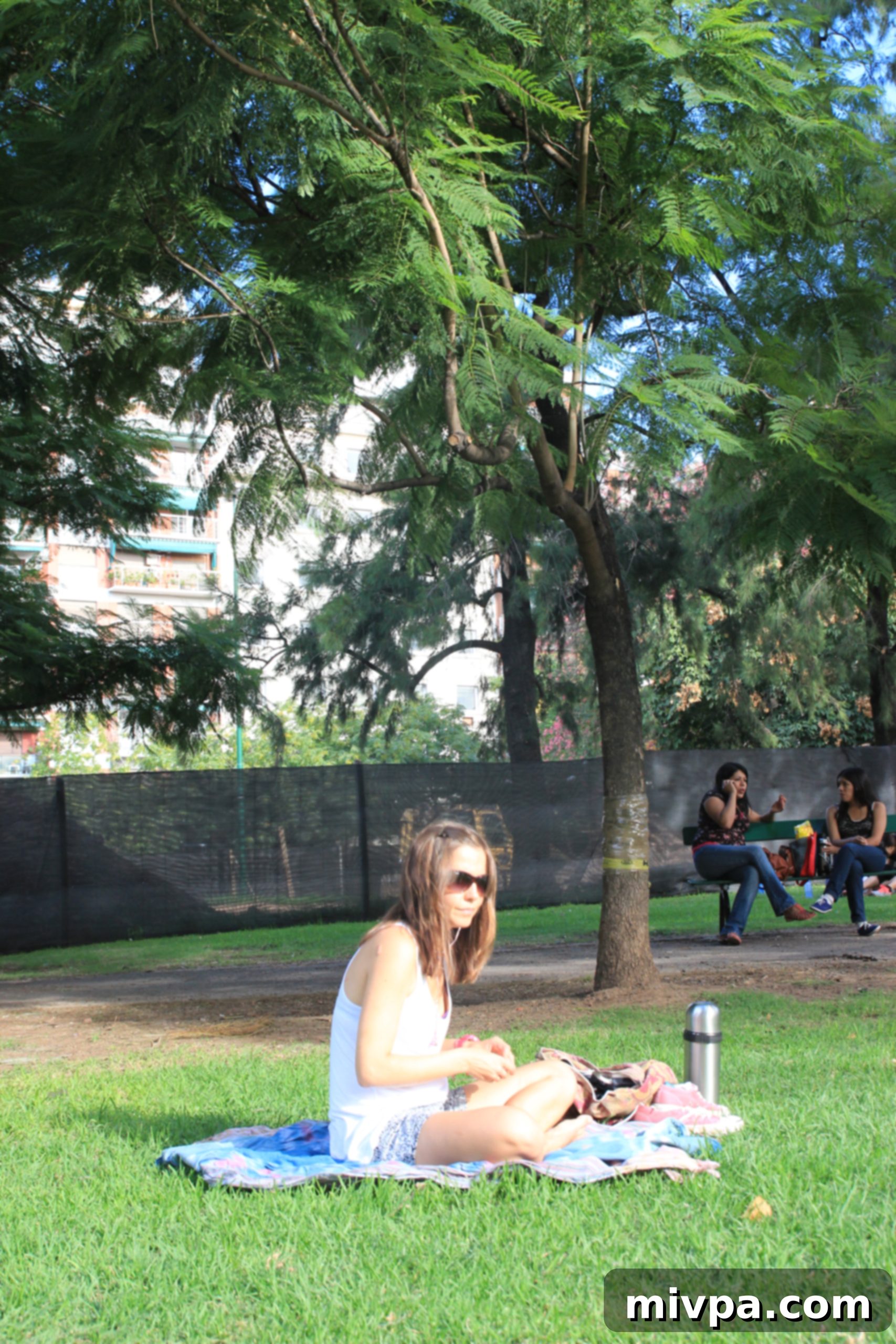 Young woman enjoying the sun and people-watching in the park