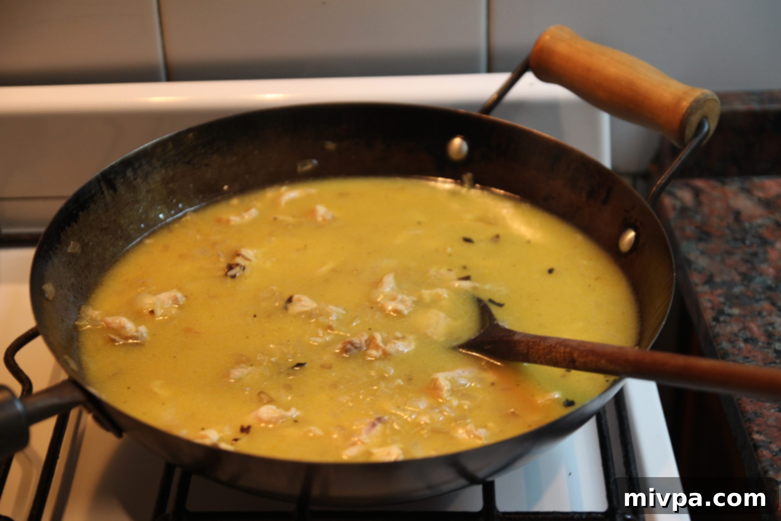 White wine and chicken stock poured into the rice mixture in the wok