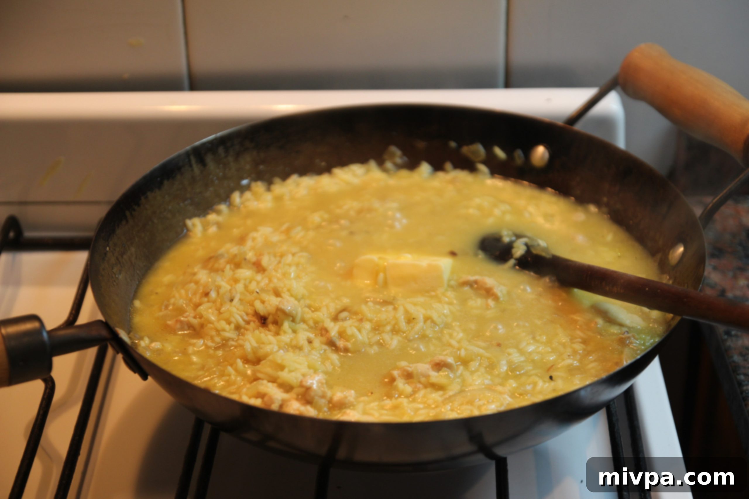 Cube of butter melting into the creamy saffron risotto
