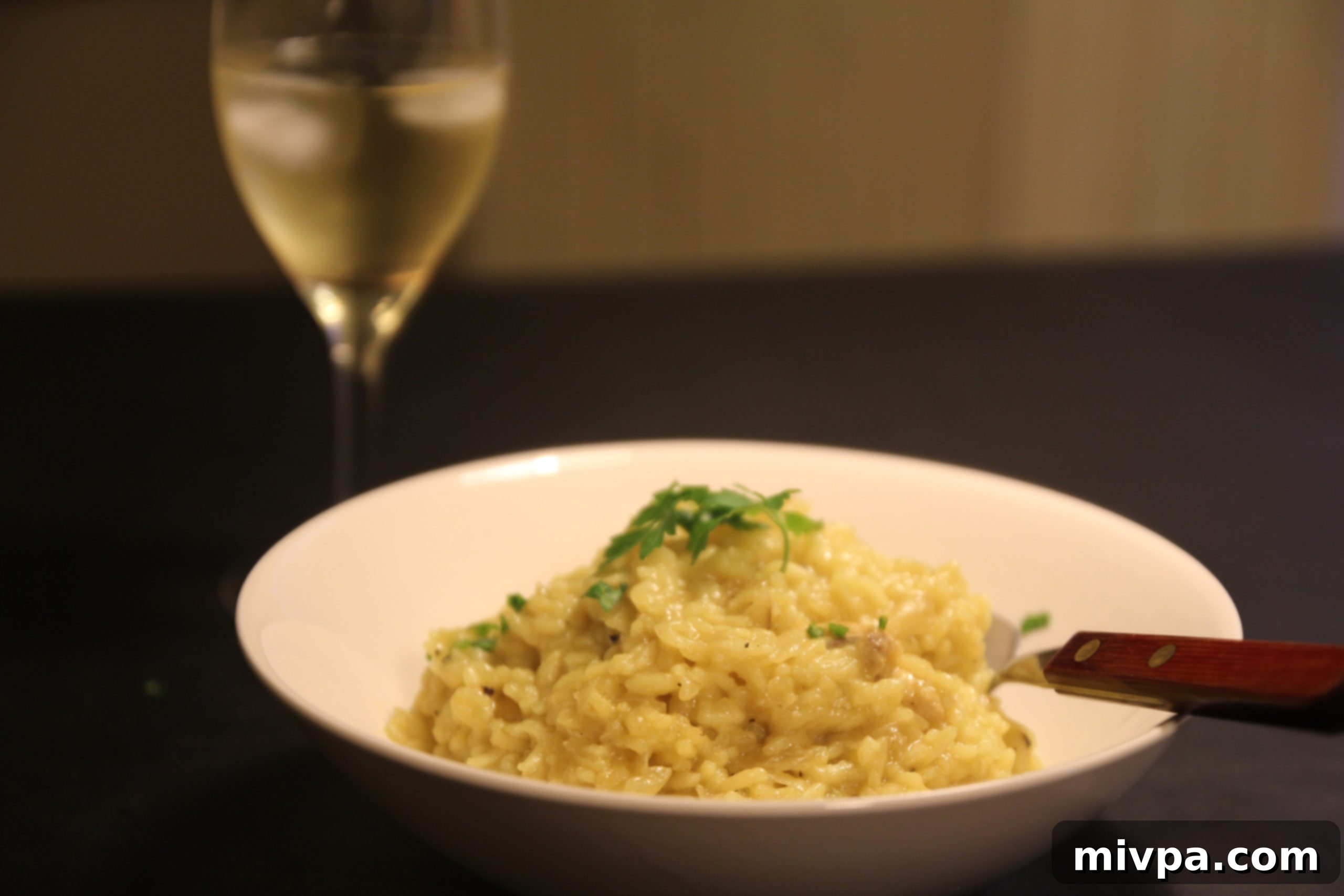 A glass of white wine complementing the chicken saffron risotto