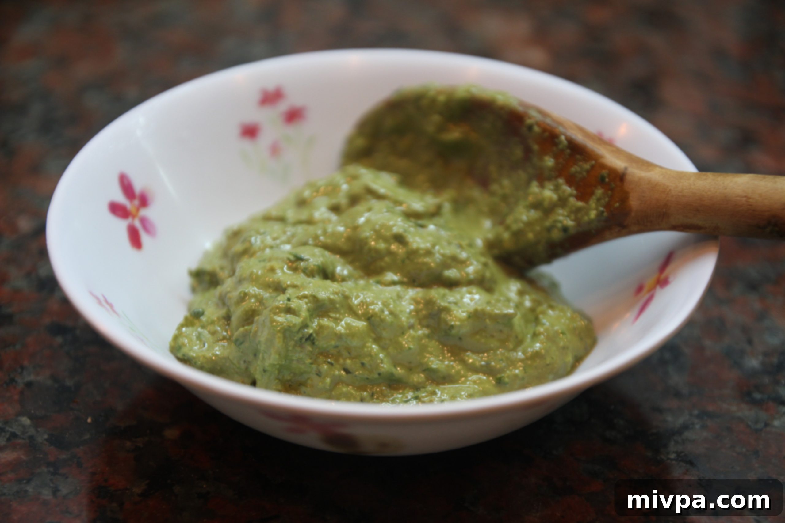 Smooth, vibrant green basil walnut pesto paste in a bowl