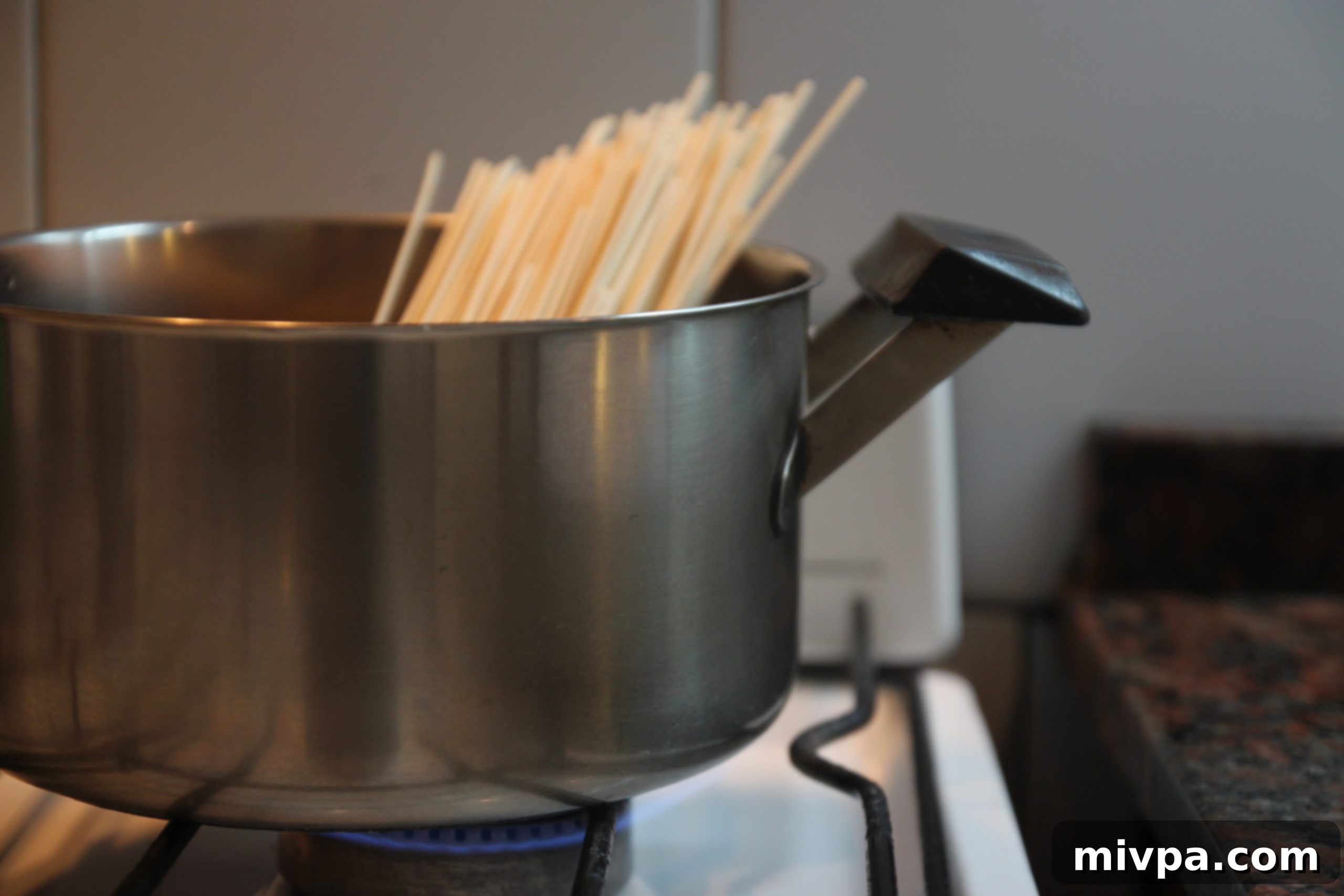 Spaghetti cooking in a pot of boiling water