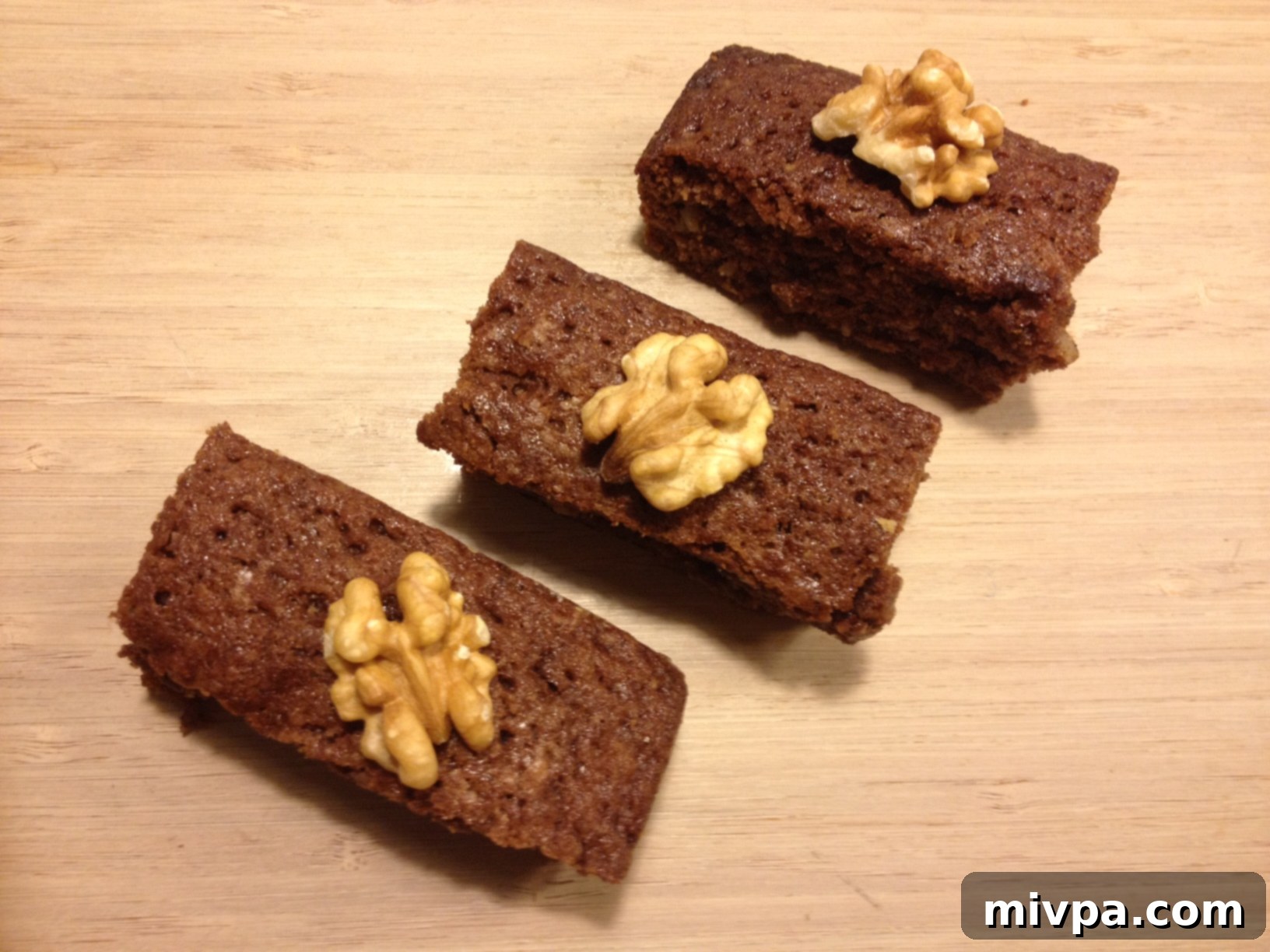 Close-up of freshly baked chocolate walnut brownies, showing fudgy texture and crunchy walnuts.