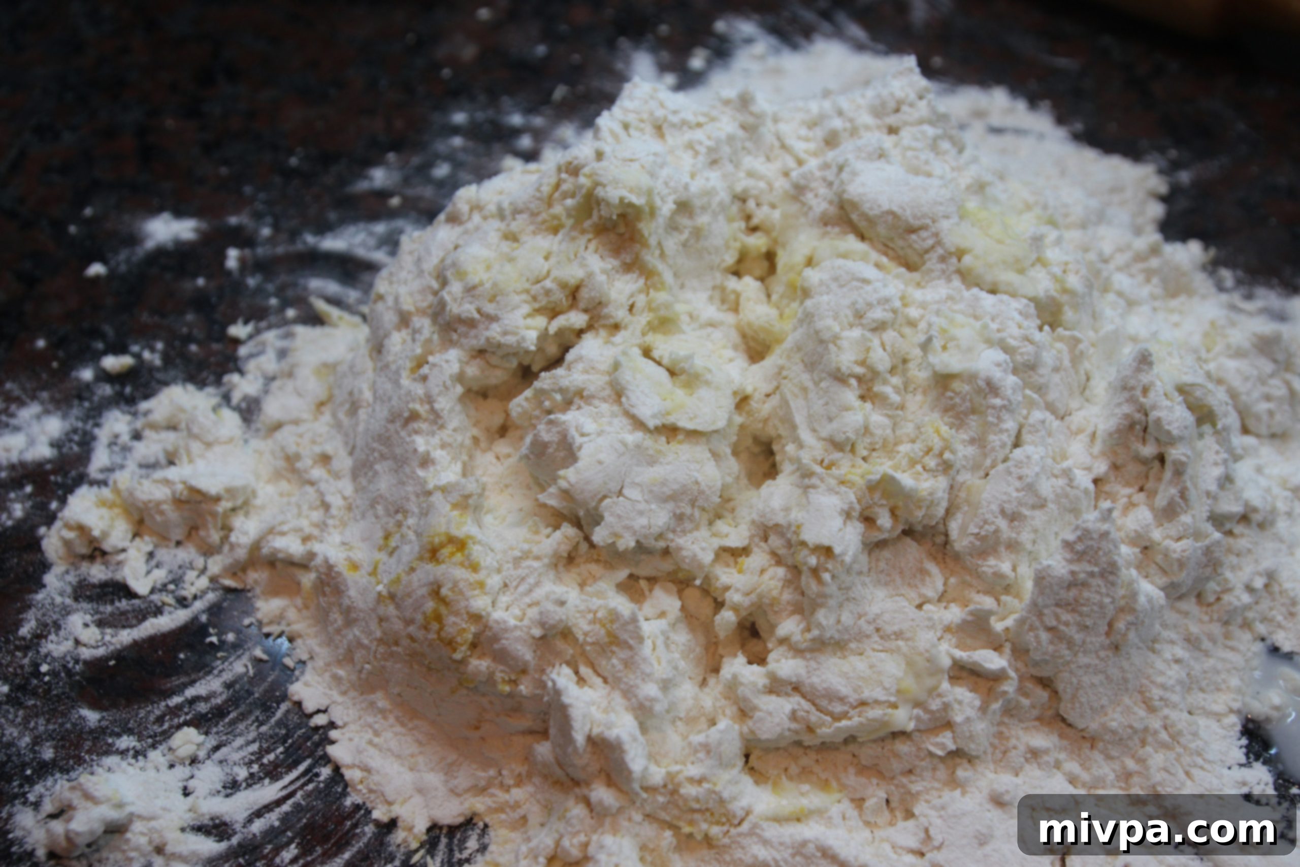 Adding water gradually to flour and eggs mixture.