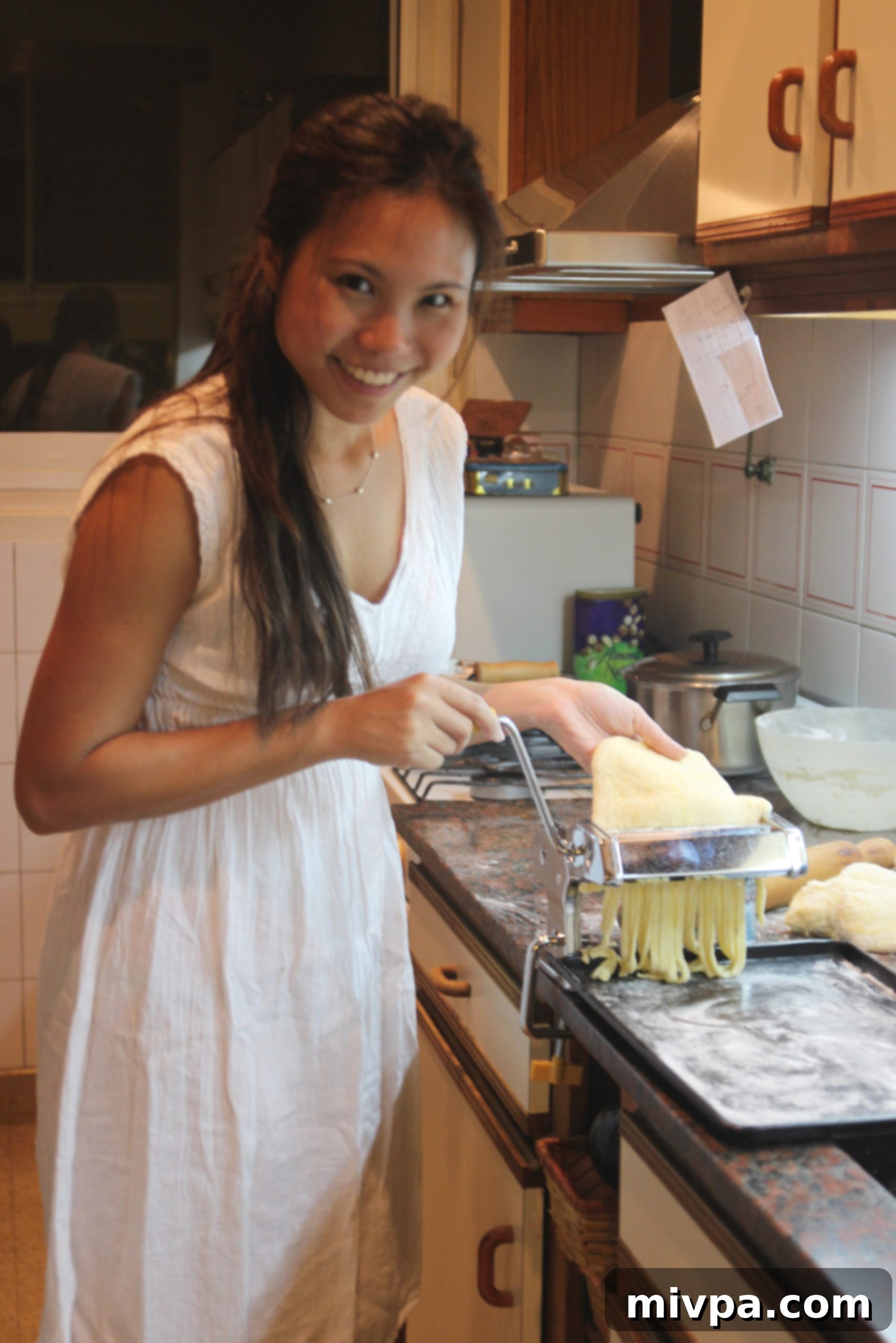Fresh pasta being extruded from a pasta machine.