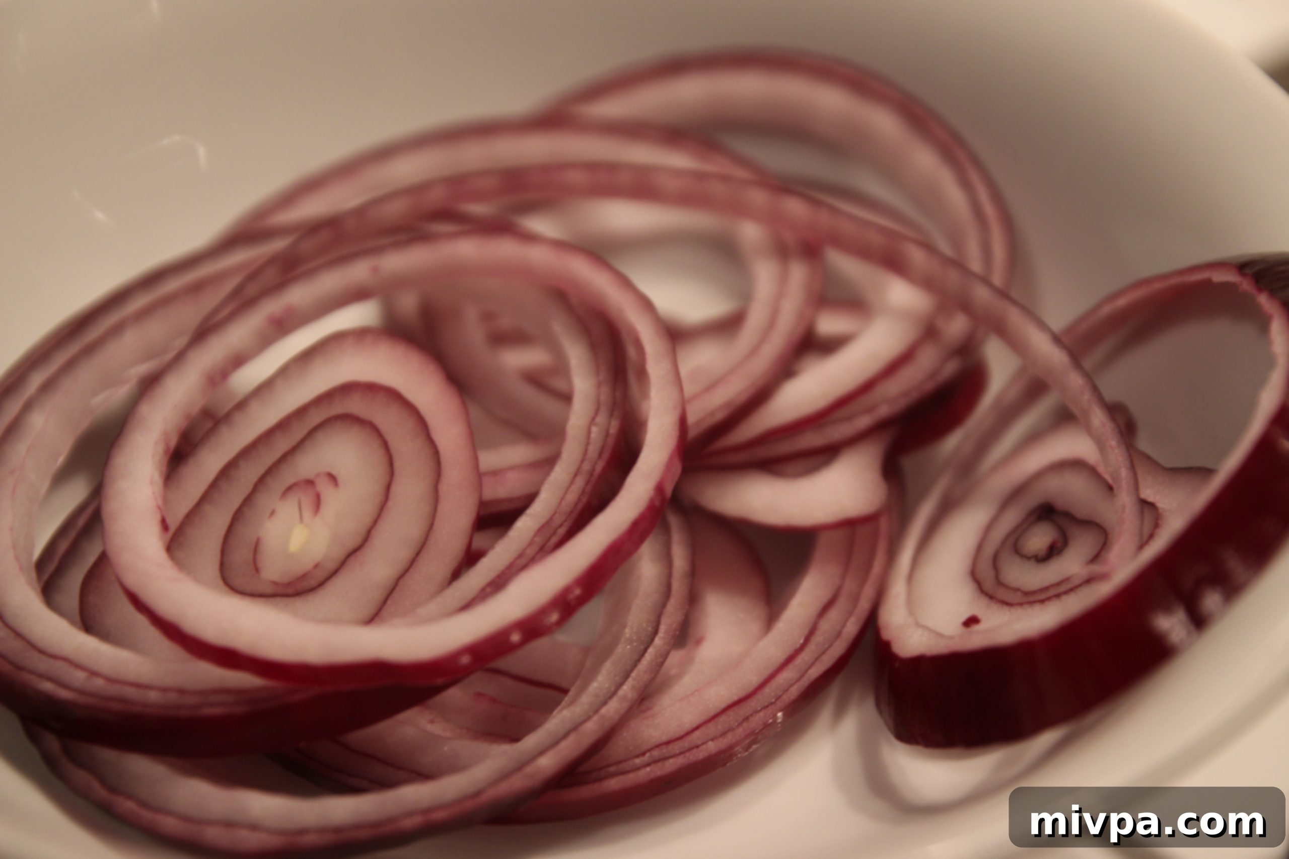 Red onion rings being prepared for garnish