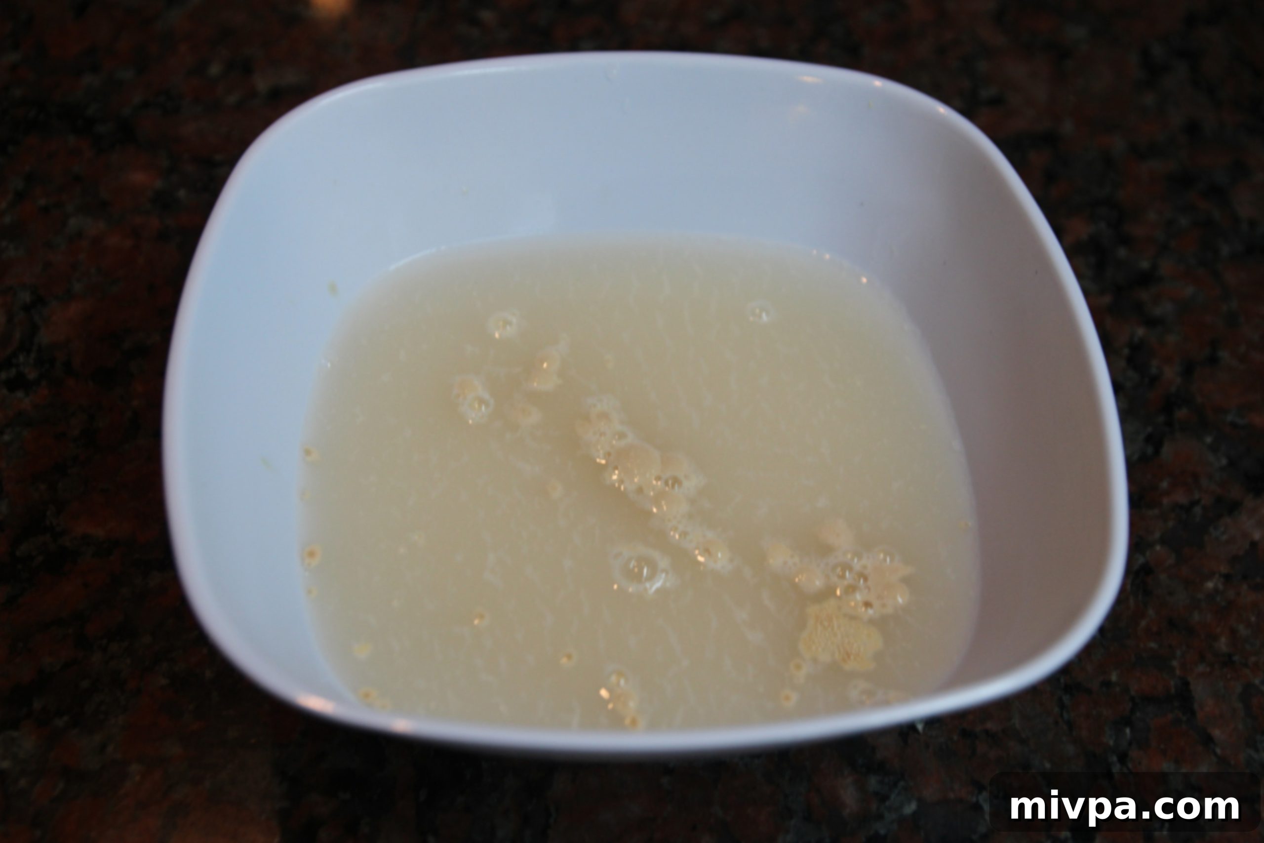 Warm water mixed with active dry yeast, frothing after 10 minutes, in a clear bowl