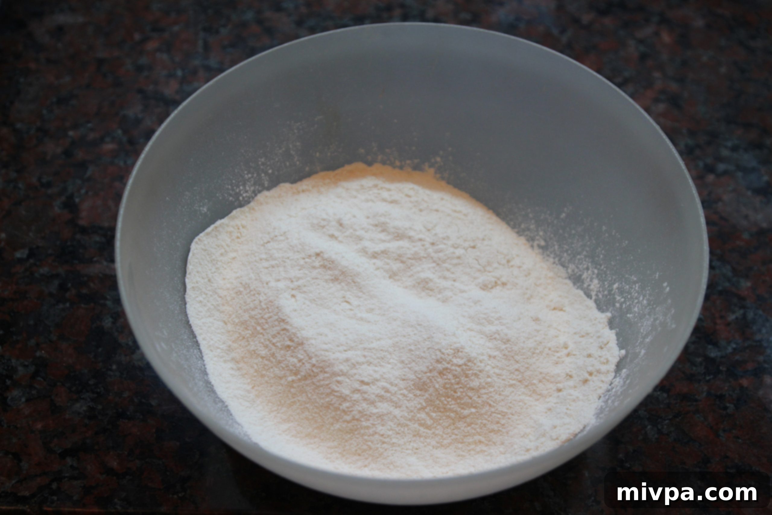 Flour and salt mixed together in a white bowl, ready for wet ingredients