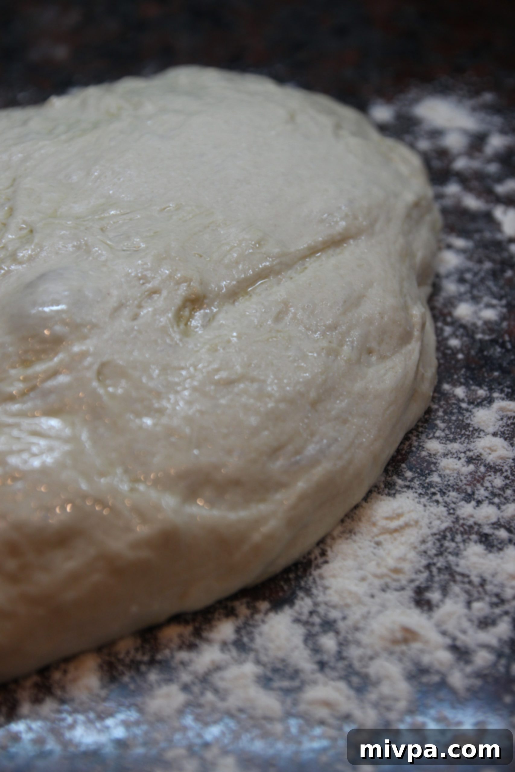 Close-up of very sticky ciabatta dough clinging to hands, resembling thick glue