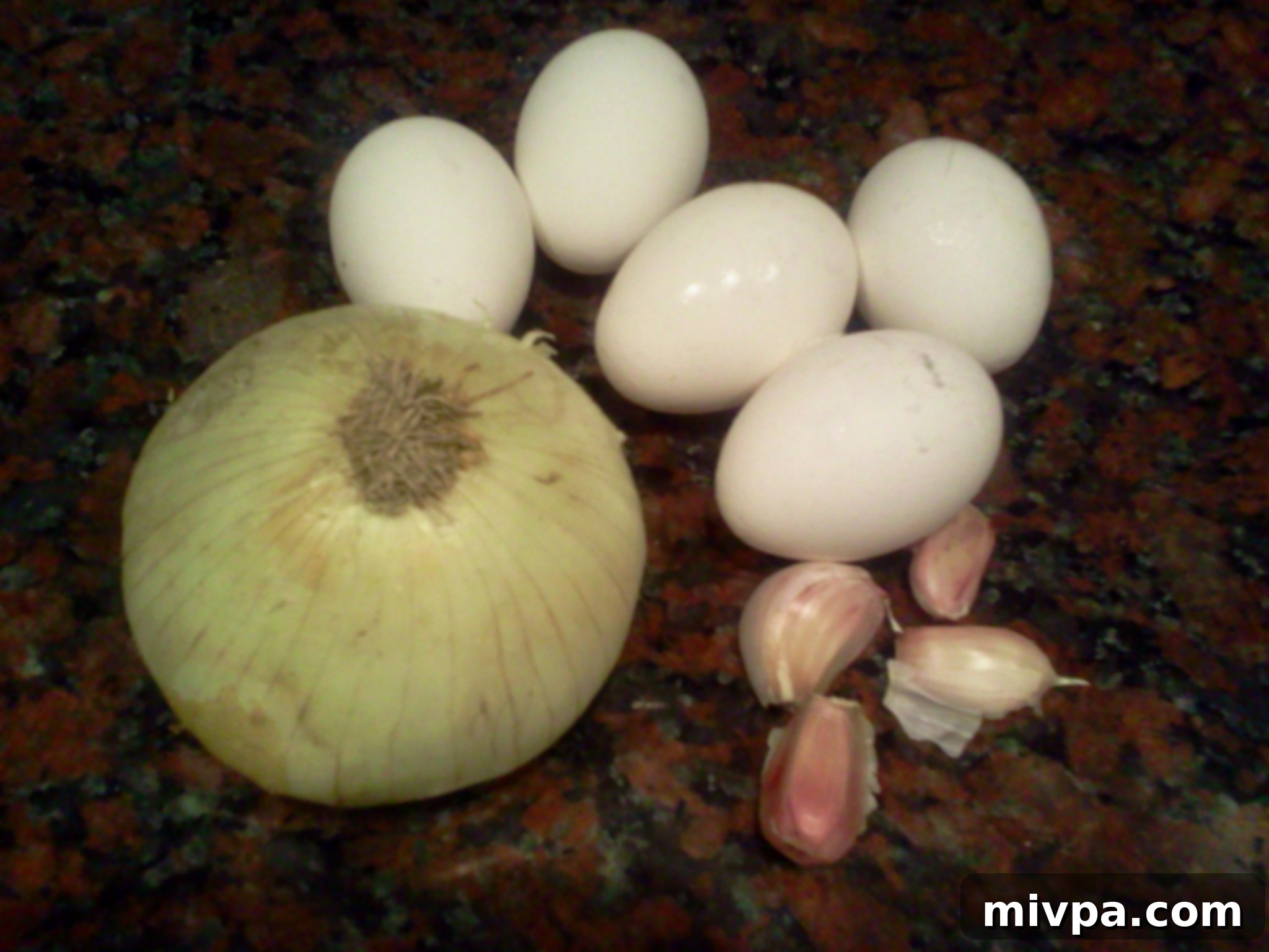 Fresh ingredients laid out: eggs, a whole onion, and garlic cloves, ready for preparing delicious fried rice.