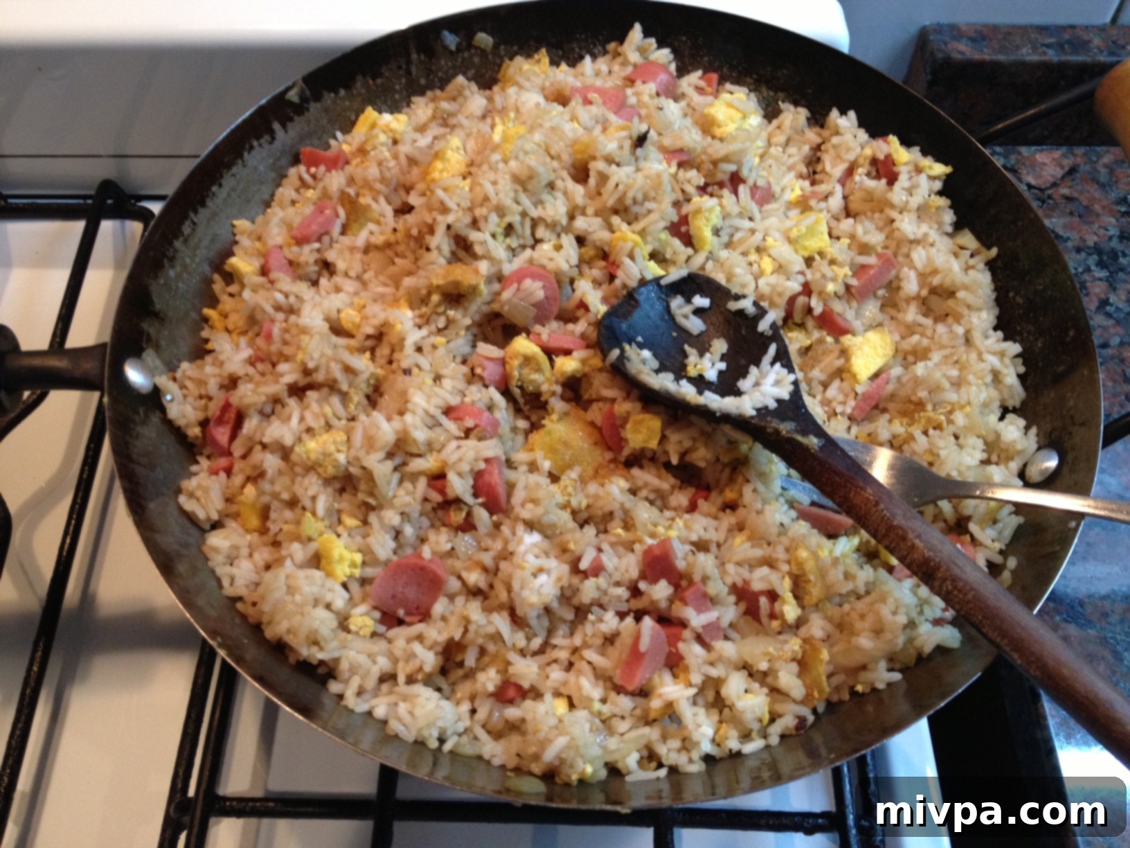 All ingredients thoroughly mixed in the wok, creating a vibrant and evenly distributed chicken sausage fried rice.