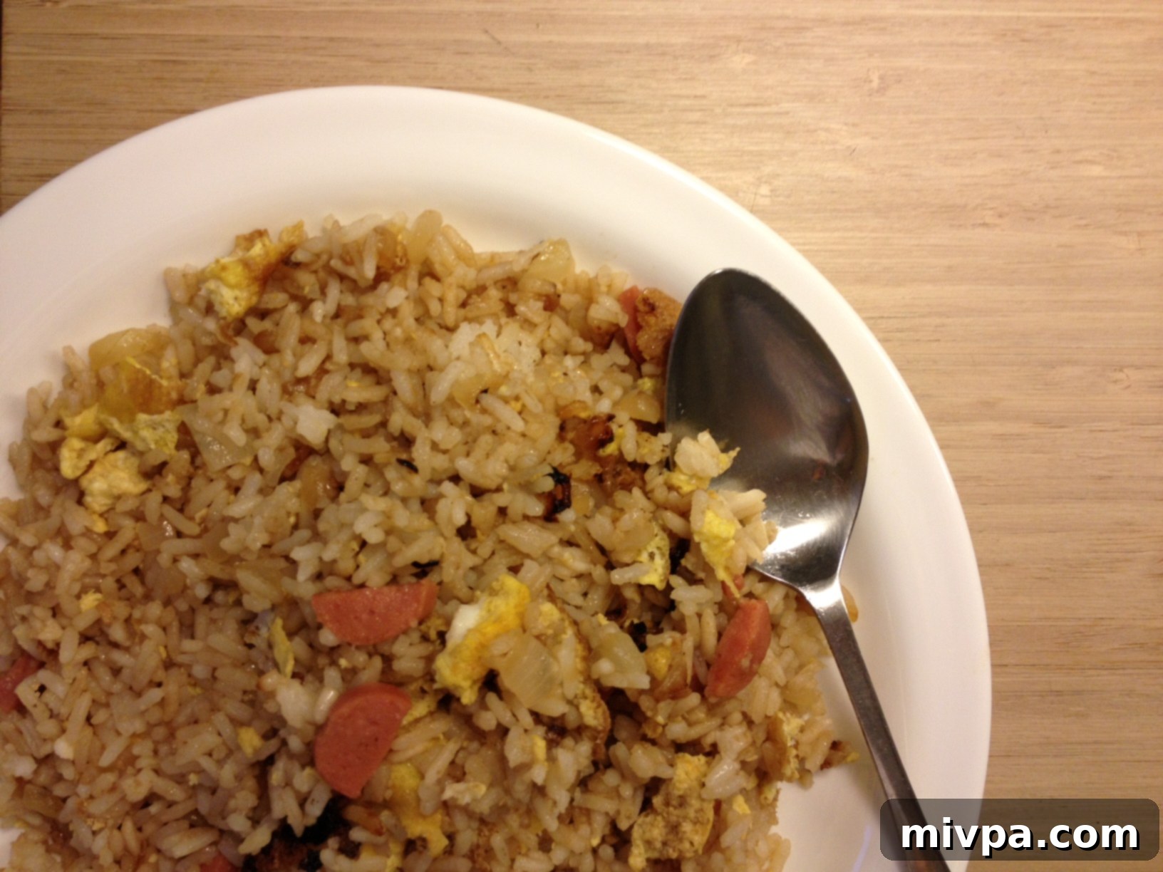 A finished plate of delicious chicken sausage fried rice, garnished and ready to be served.