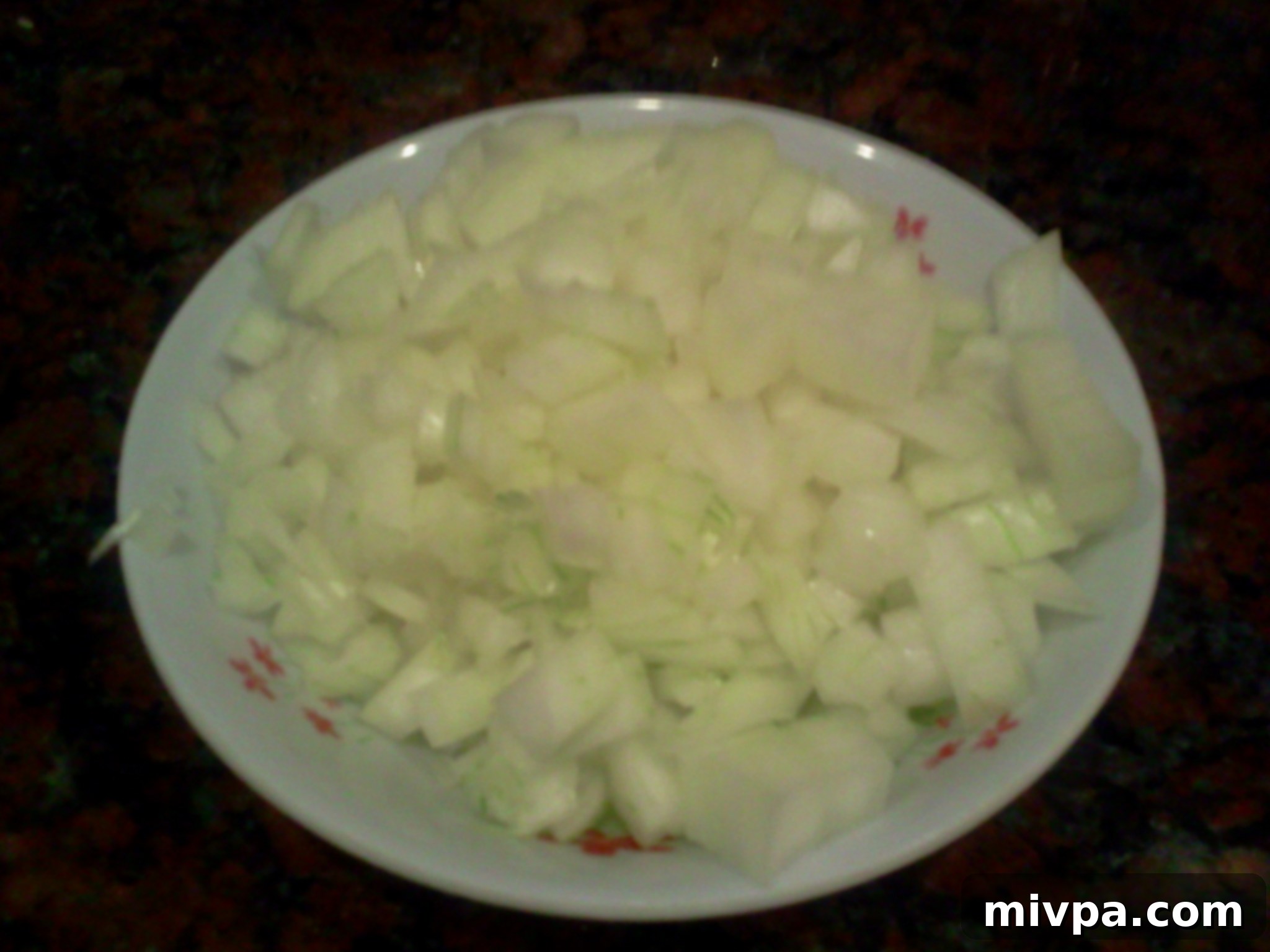 Finely chopped onions on a cutting board, ready to be stir-fried for the fried rice base.