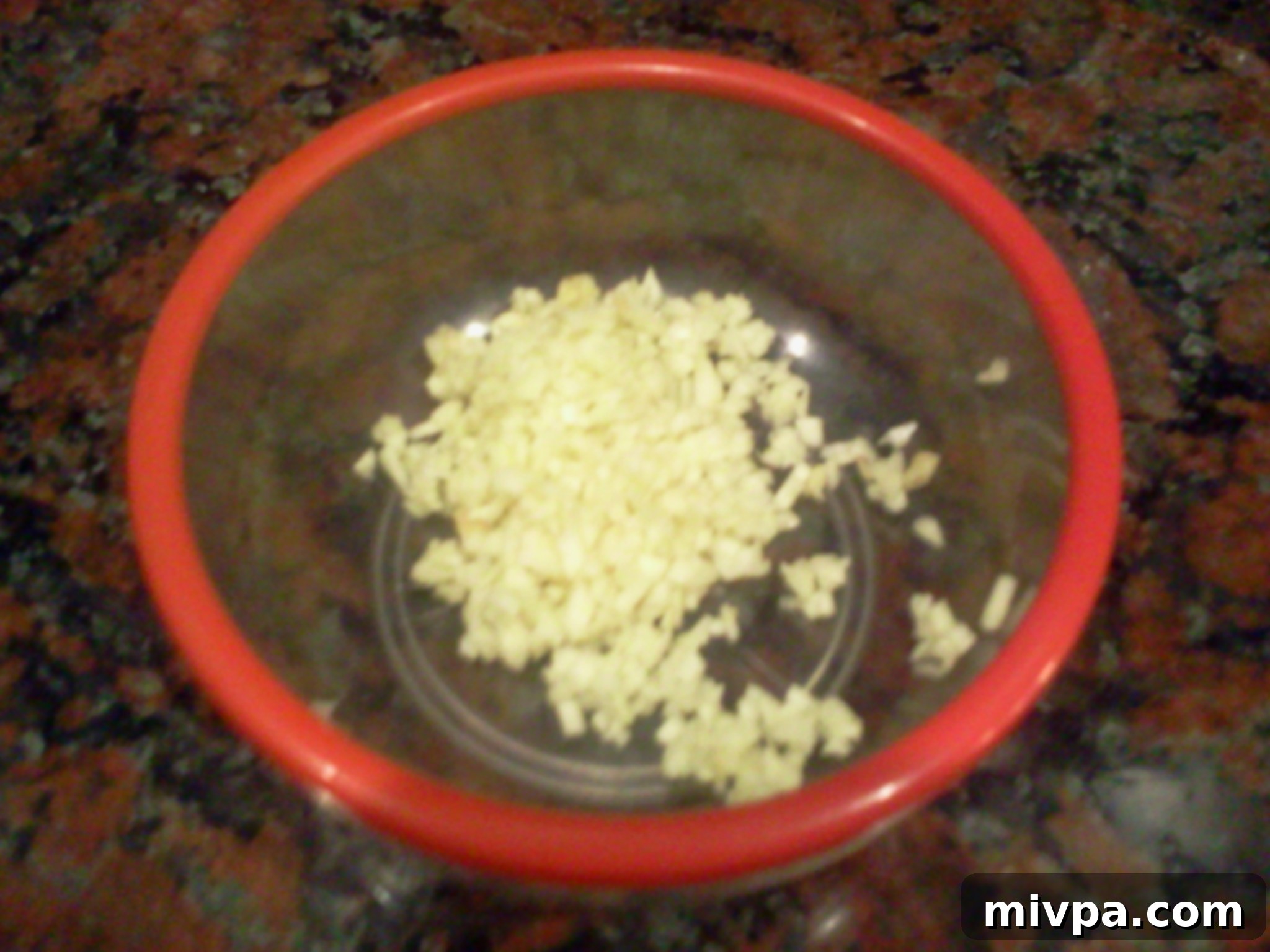 Minced garlic cloves, prepared to infuse the fried rice with aromatic flavor.
