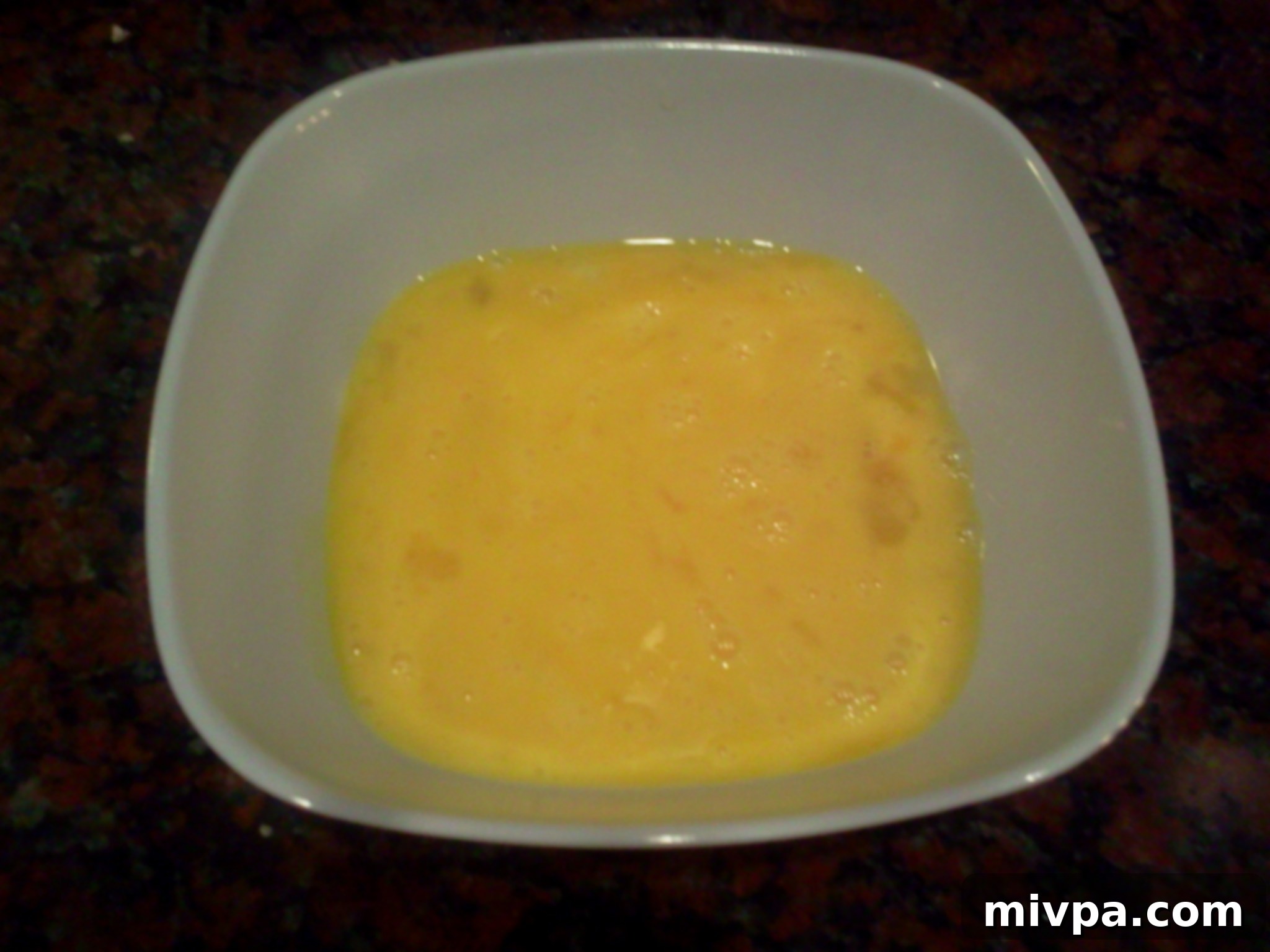 Eggs lightly beaten in a bowl, prepared for making a fluffy omelette for the fried rice.