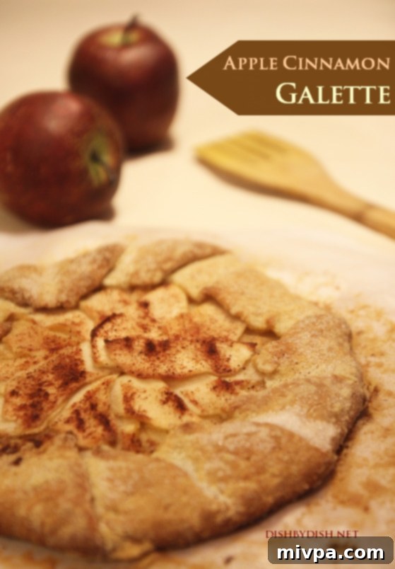 A beautifully baked Apple Cinnamon Galette, golden brown and rustic, invitingly presented on a wooden surface.