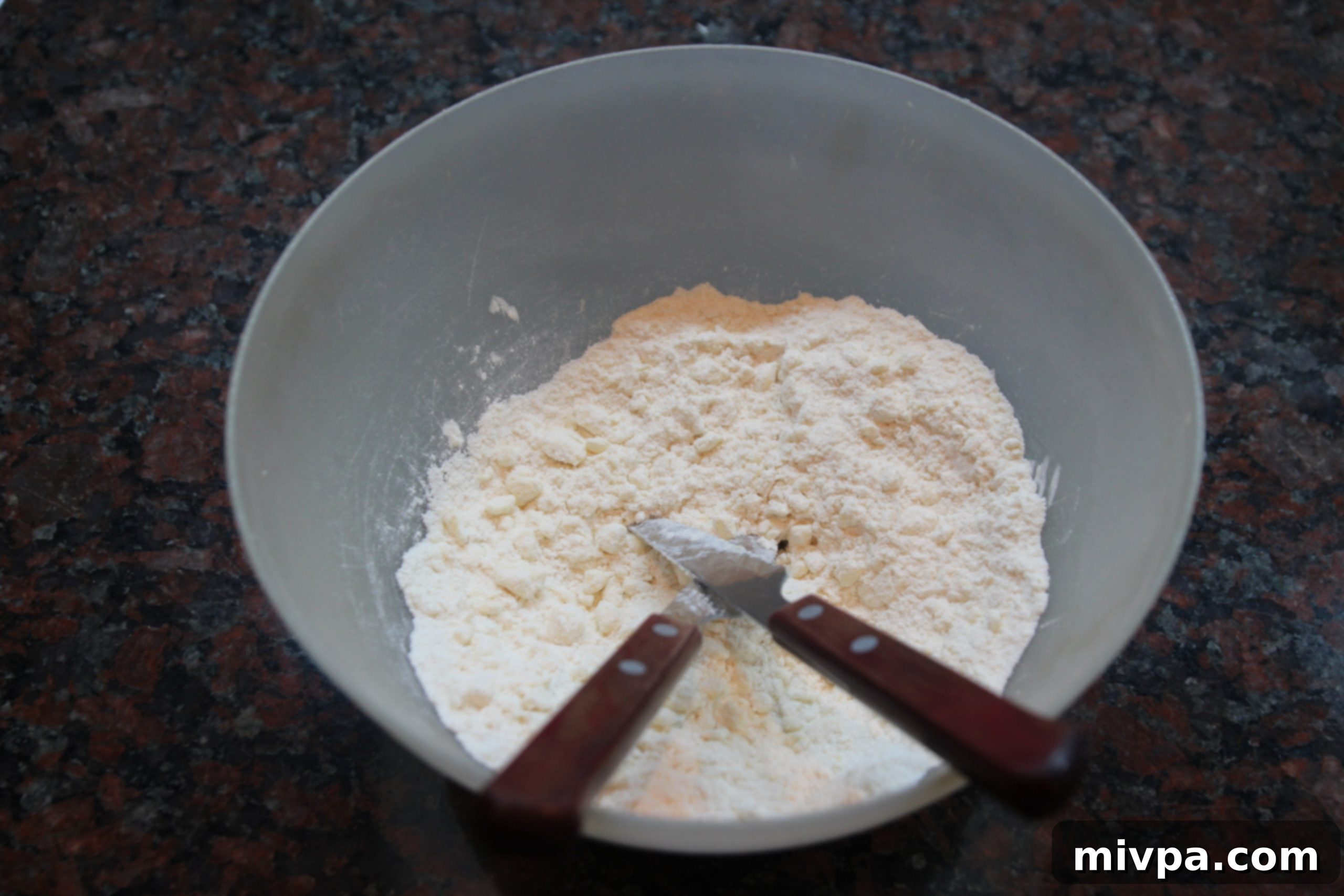 Close-up of the pastry mixture resembling fine breadcrumbs after butter has been cut in.