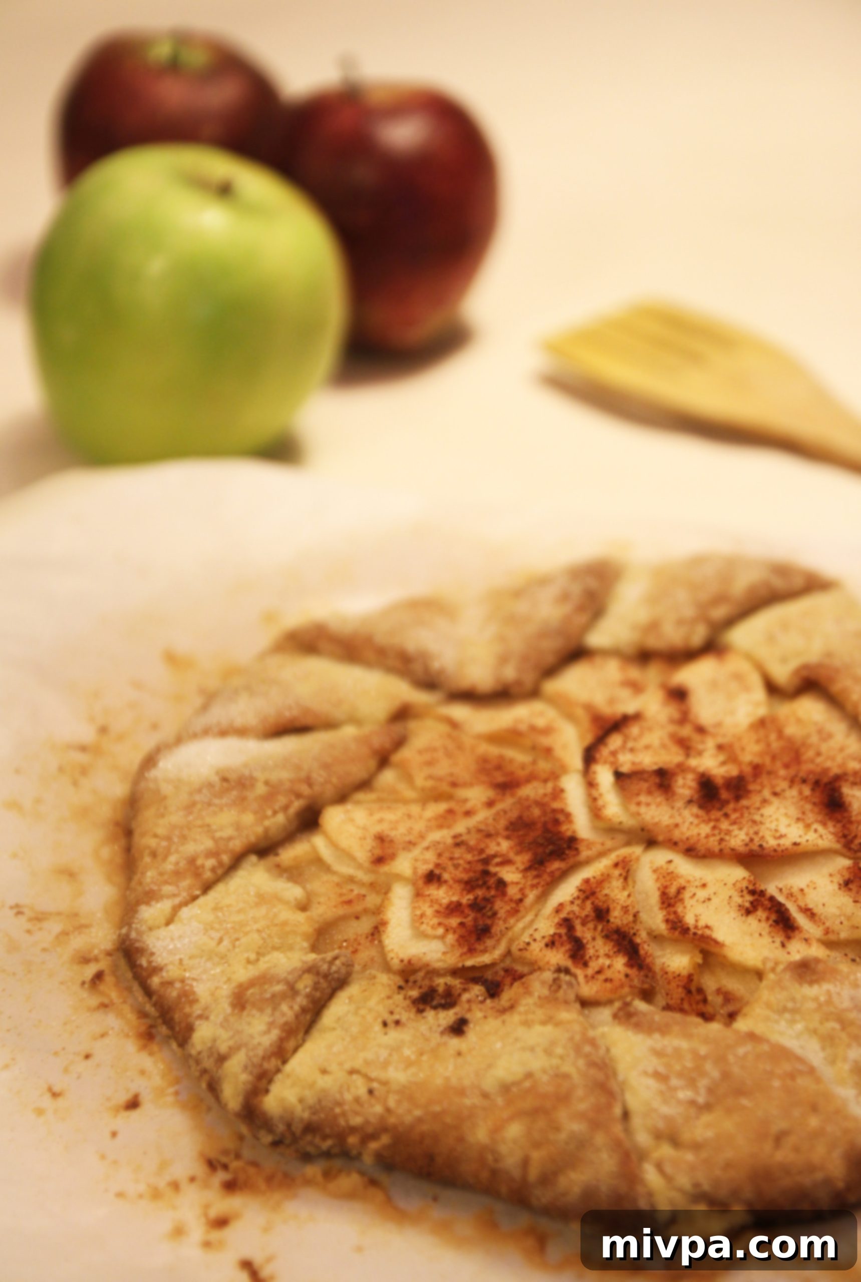 A single slice of warm Apple Cinnamon Galette, served on a white plate with a scoop of creamy vanilla ice cream.