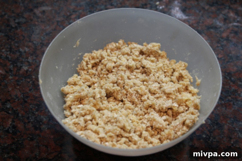 Cutting butter into flour mixture with two knives to form a crumbly dough.