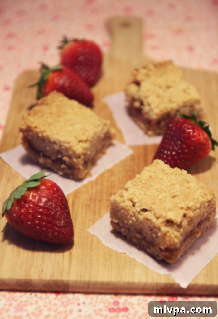 Ingredients for strawberry oatmeal bars, including a bowl of fresh strawberries.