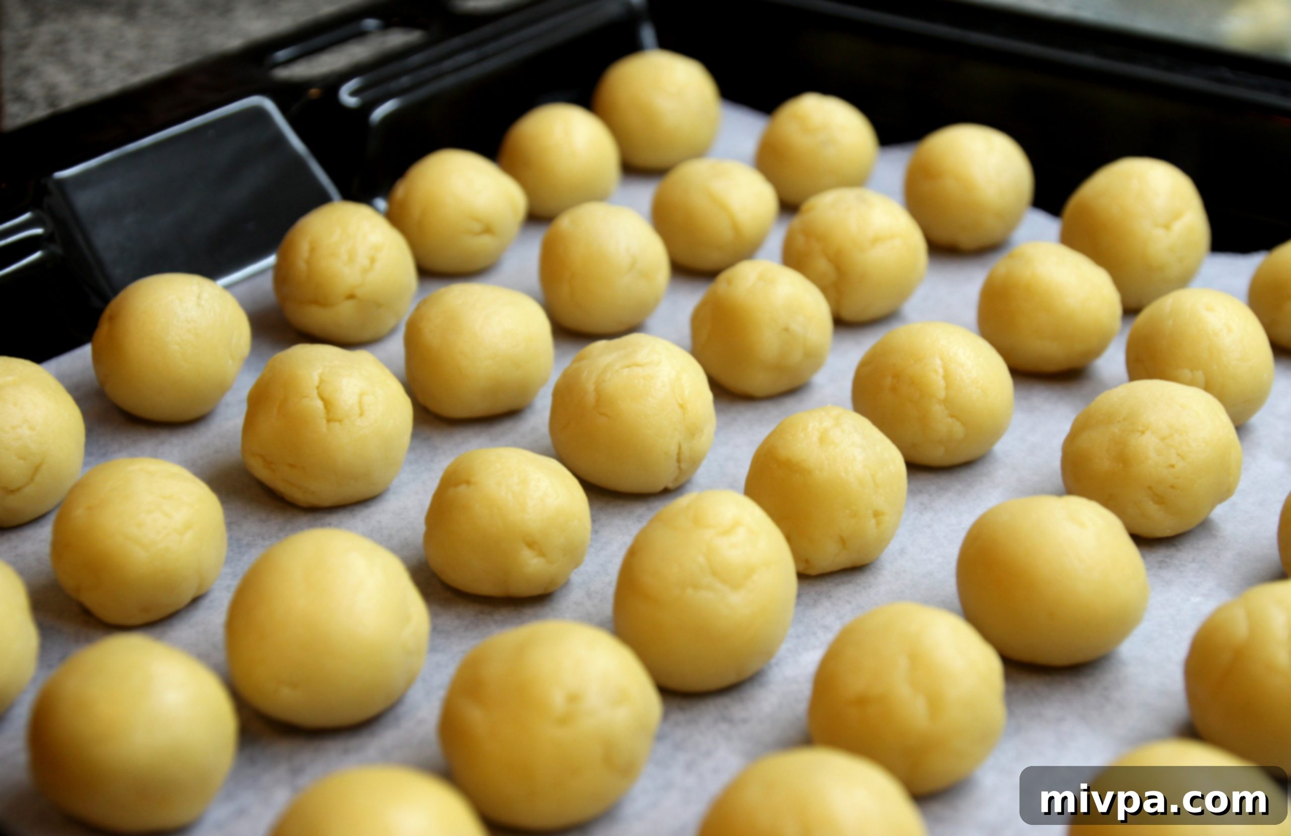 Arranging pineapple tarts on a baking sheet