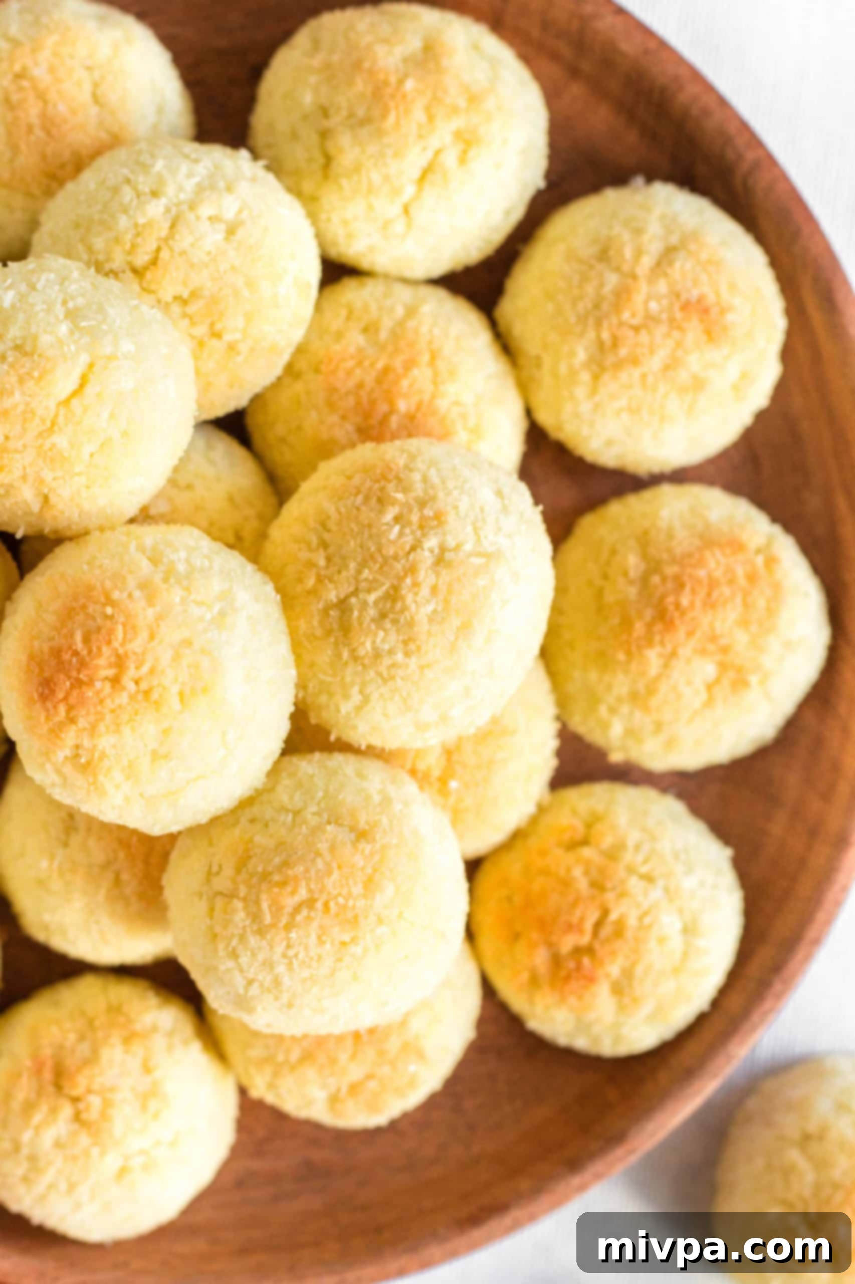 Easy Coconut Macaroons (Gluten-Free, Dairy-Free) - In a Glass Bowl A close-up shot of a large glass bowl filled with freshly baked gluten-free coconut macaroons, highlighting their texture.